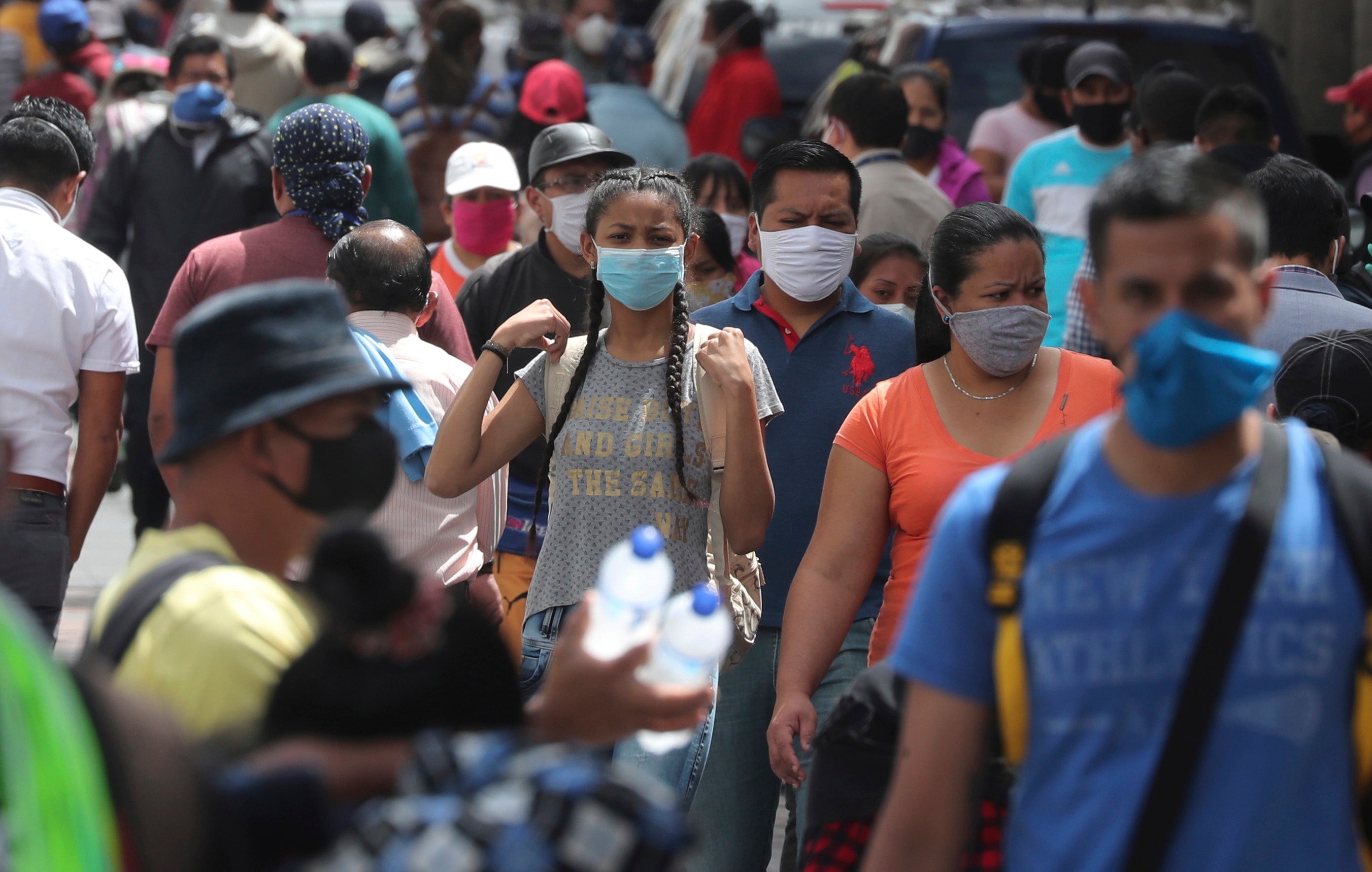 People wearing masks walk downtown amid the new coronavirus pandemic in Quito, Ecuador on Monday, June 29, 2020.
