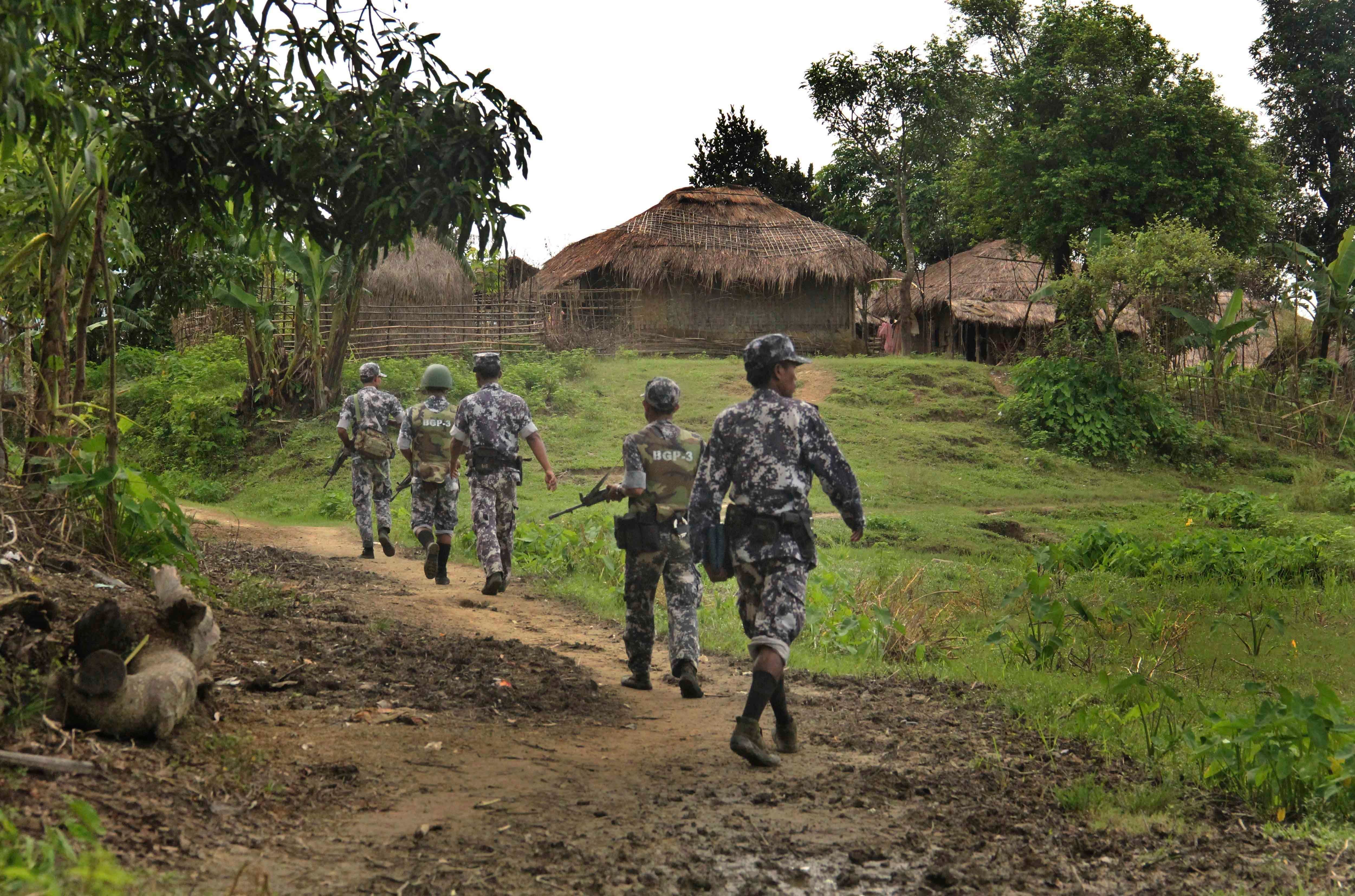 Myanmar border guard police officers walk along a path in Tin May village in northern Rakhine State, Myanmar, July 14, 2017.