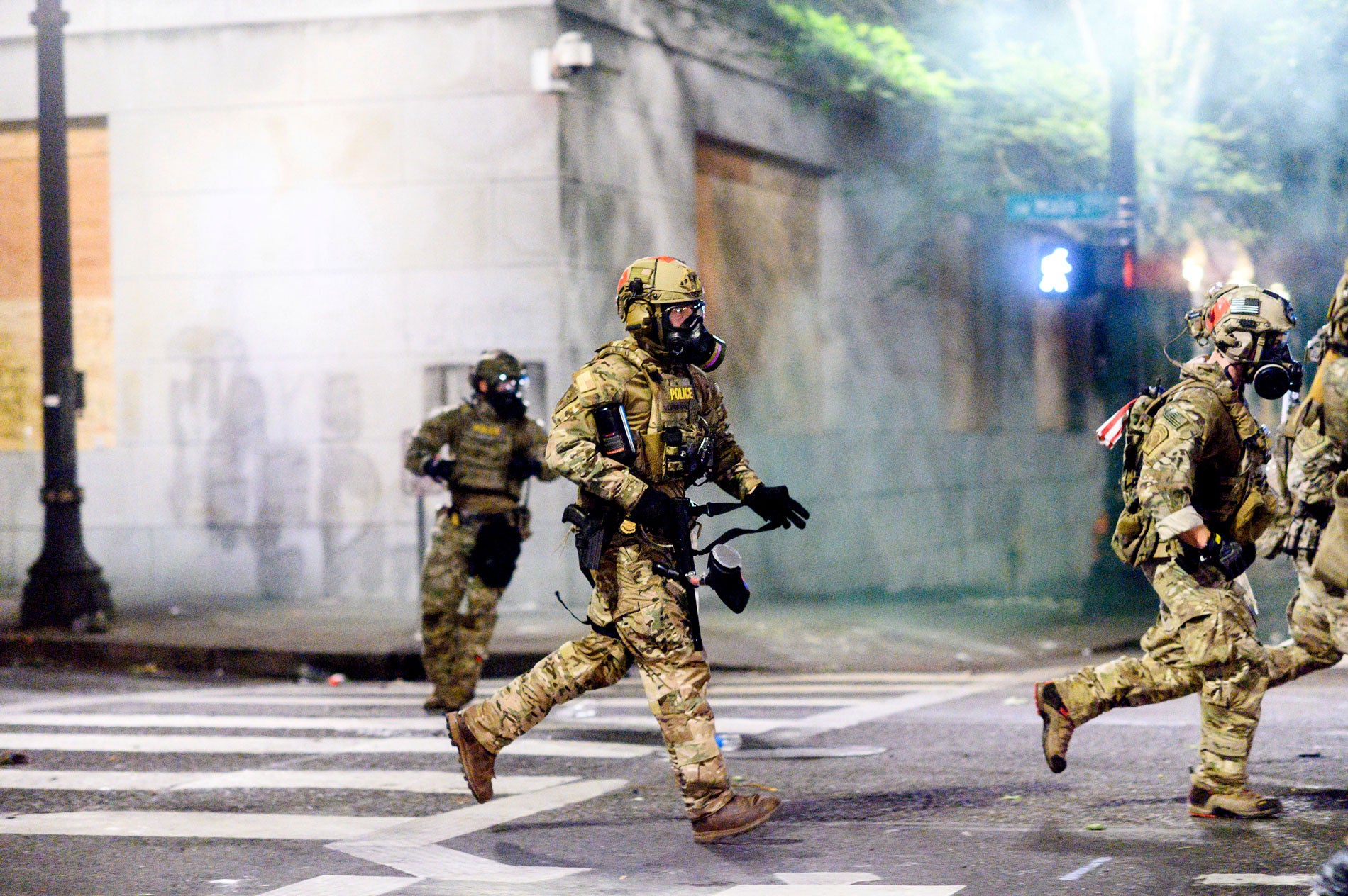 Federal officers run after dispersing protesters in Portland, Oregon, July 22, 2020.