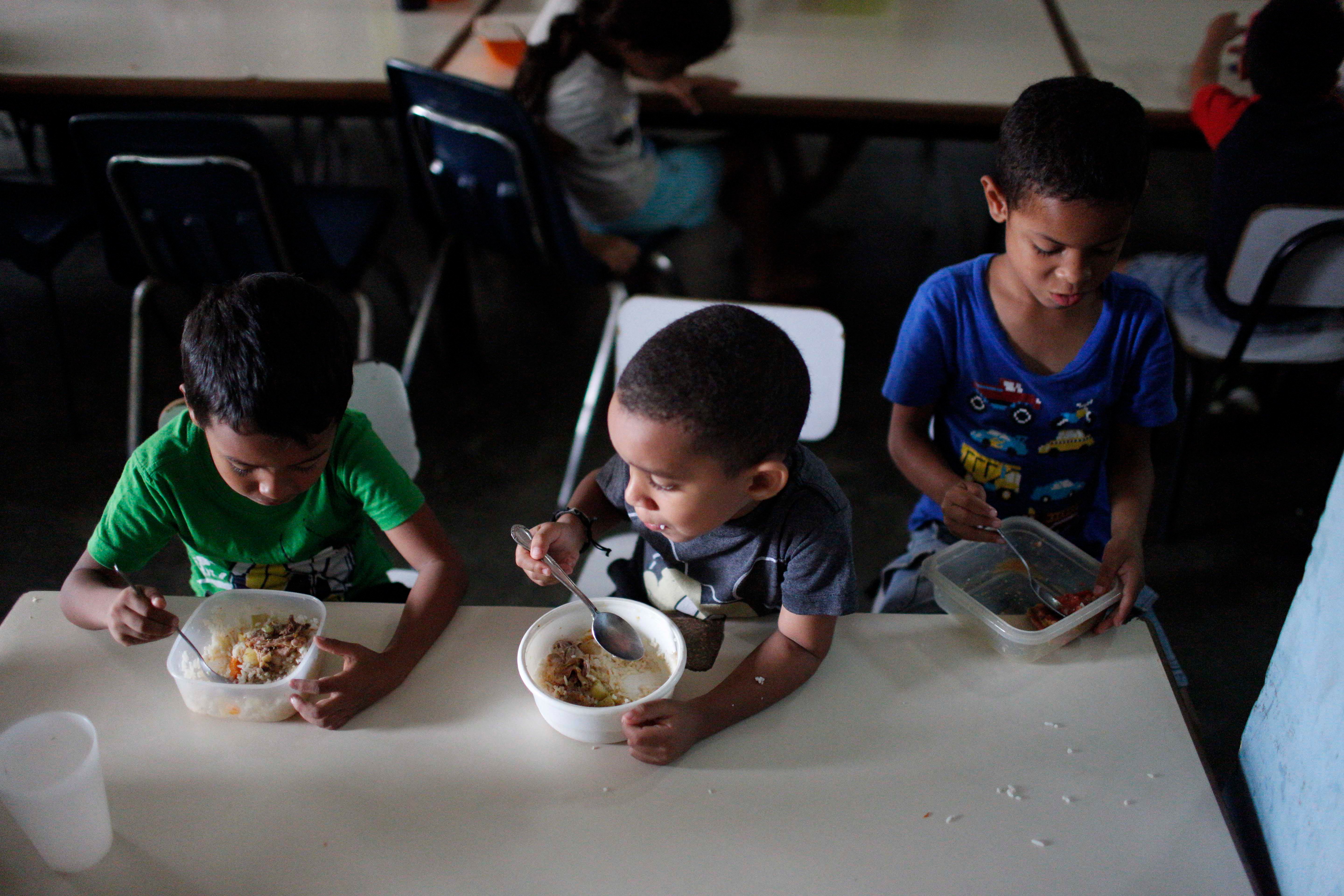Children eat lunch at Madre Asunción's community kitchen, which is ran by the NGO Alimenta La Solidaridad, on October 9, 2019 in Petare, Caracas, Venezuela.