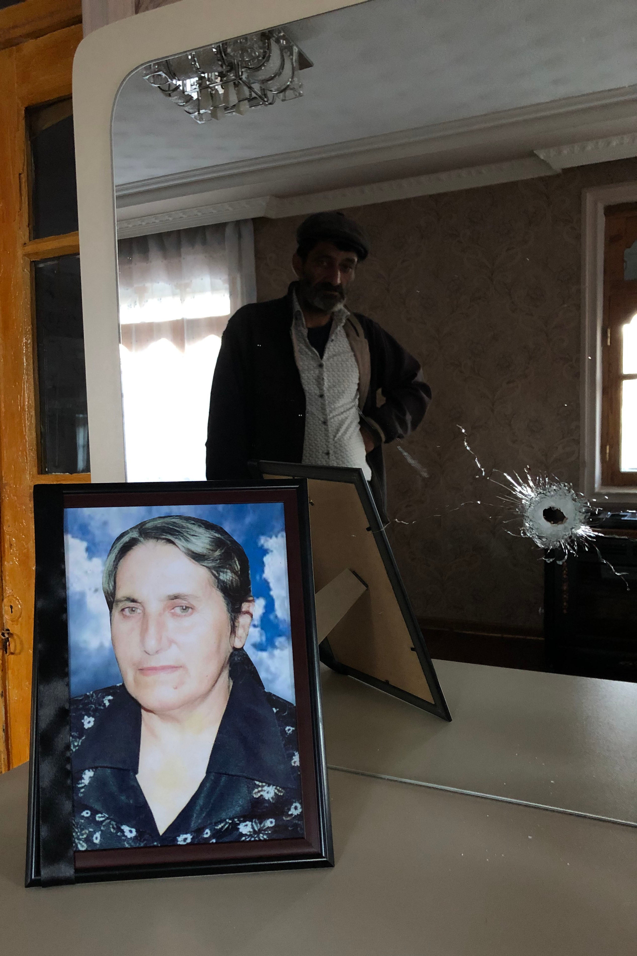Yashar Abbasov keeps a photograph of his wife, Raziya Abbasova, on a dresser with a mirror which was damaged in the attack that killed her. 