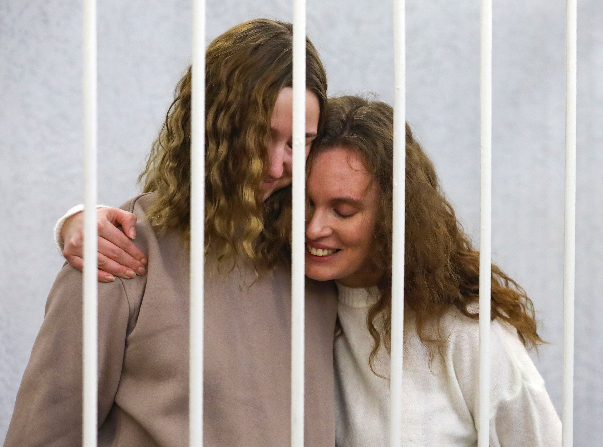 Journalists Ekaterina Andreyeva (Bakhvalova), right, and Daria Chultsova embrace inside the defendants' cage during a court hearing in Minsk, Belarus, February 9, 2021. 