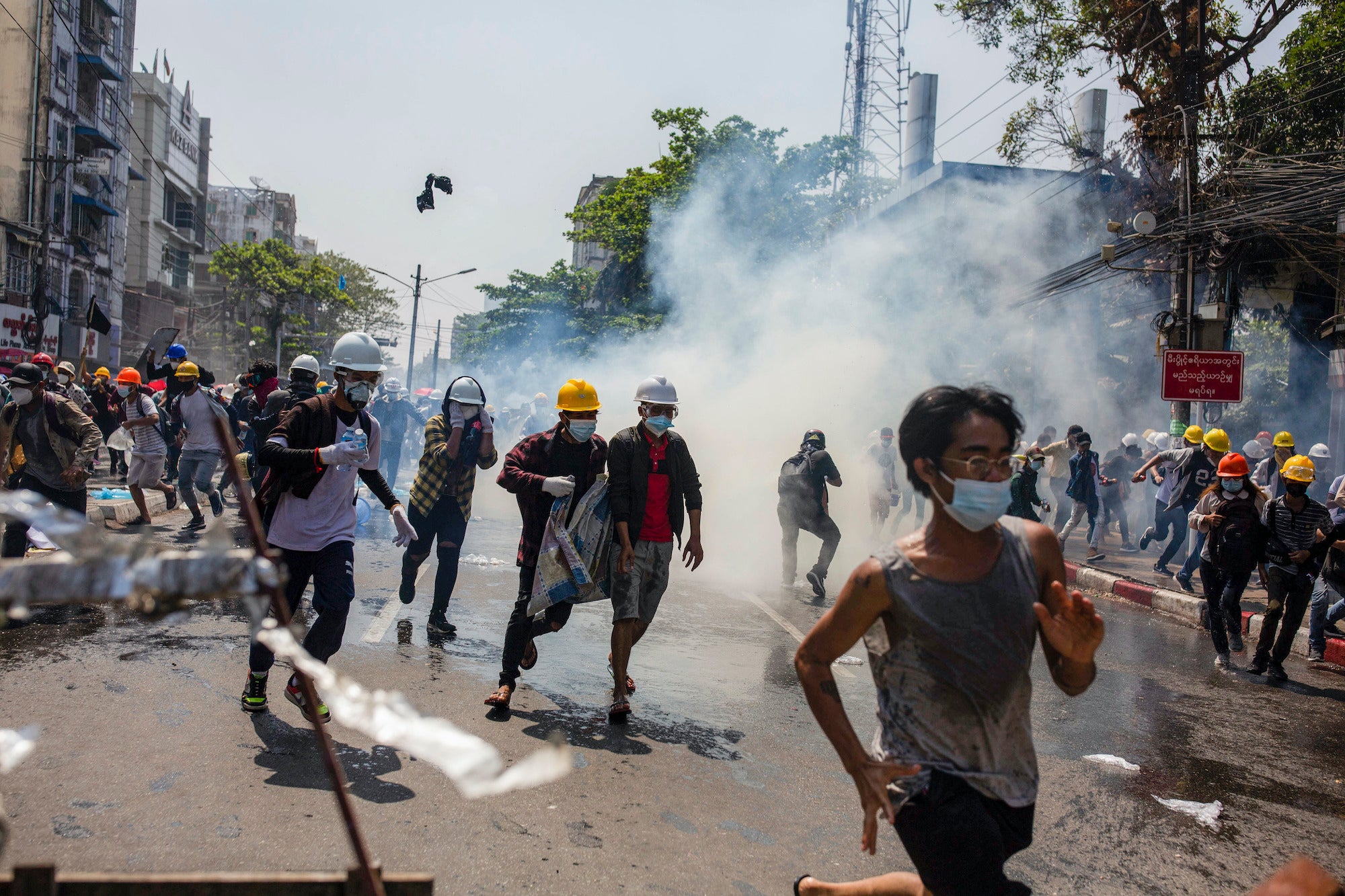 Anti-coup protesters run from teargas deployed by the police during a demonstration in Yangon, Myanmar, March 1, 2021.