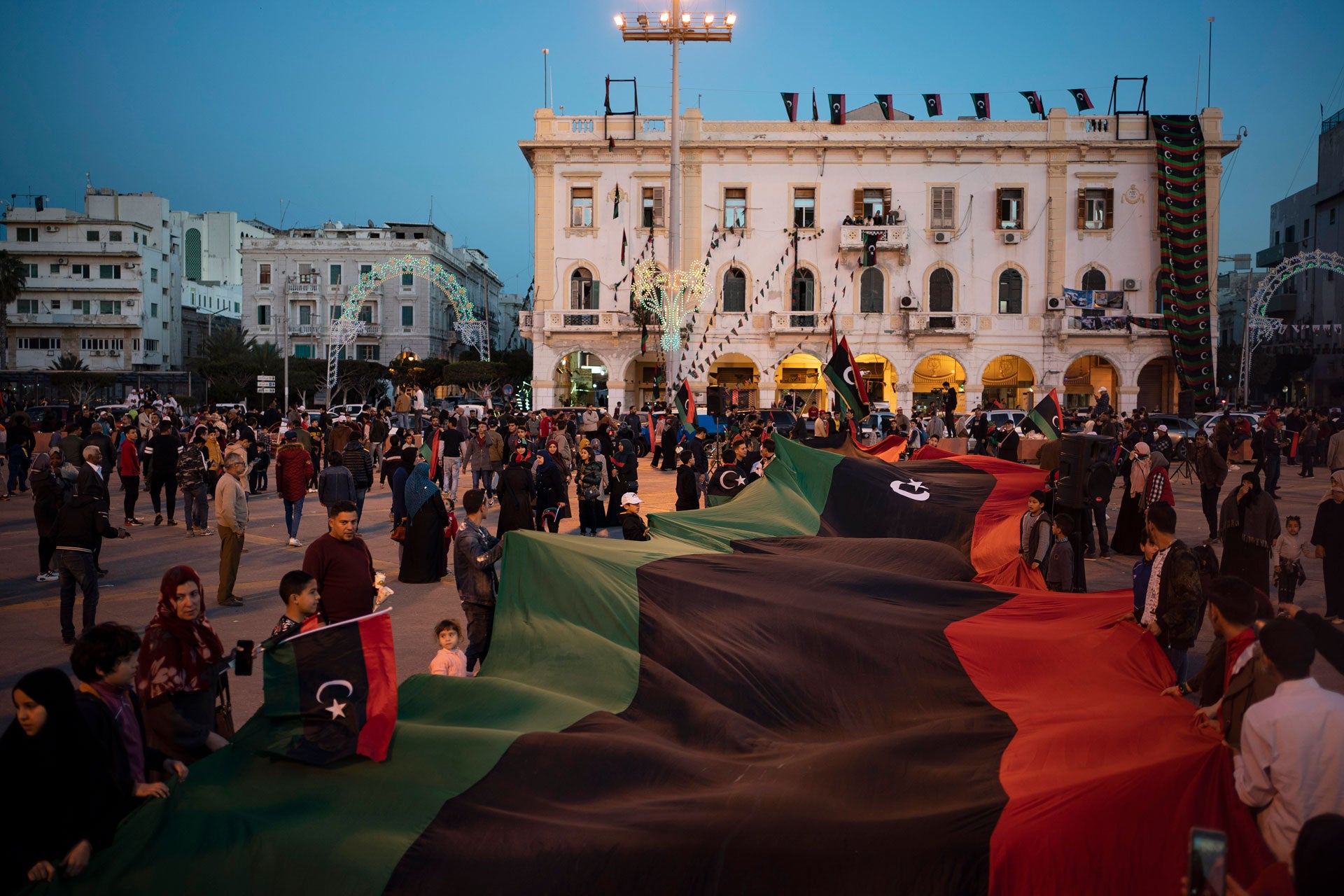 People carry a Libyan flag at Martyr square during a march commemorating the anniversary of protests in Tripoli, Libya, February 25, 2020. 