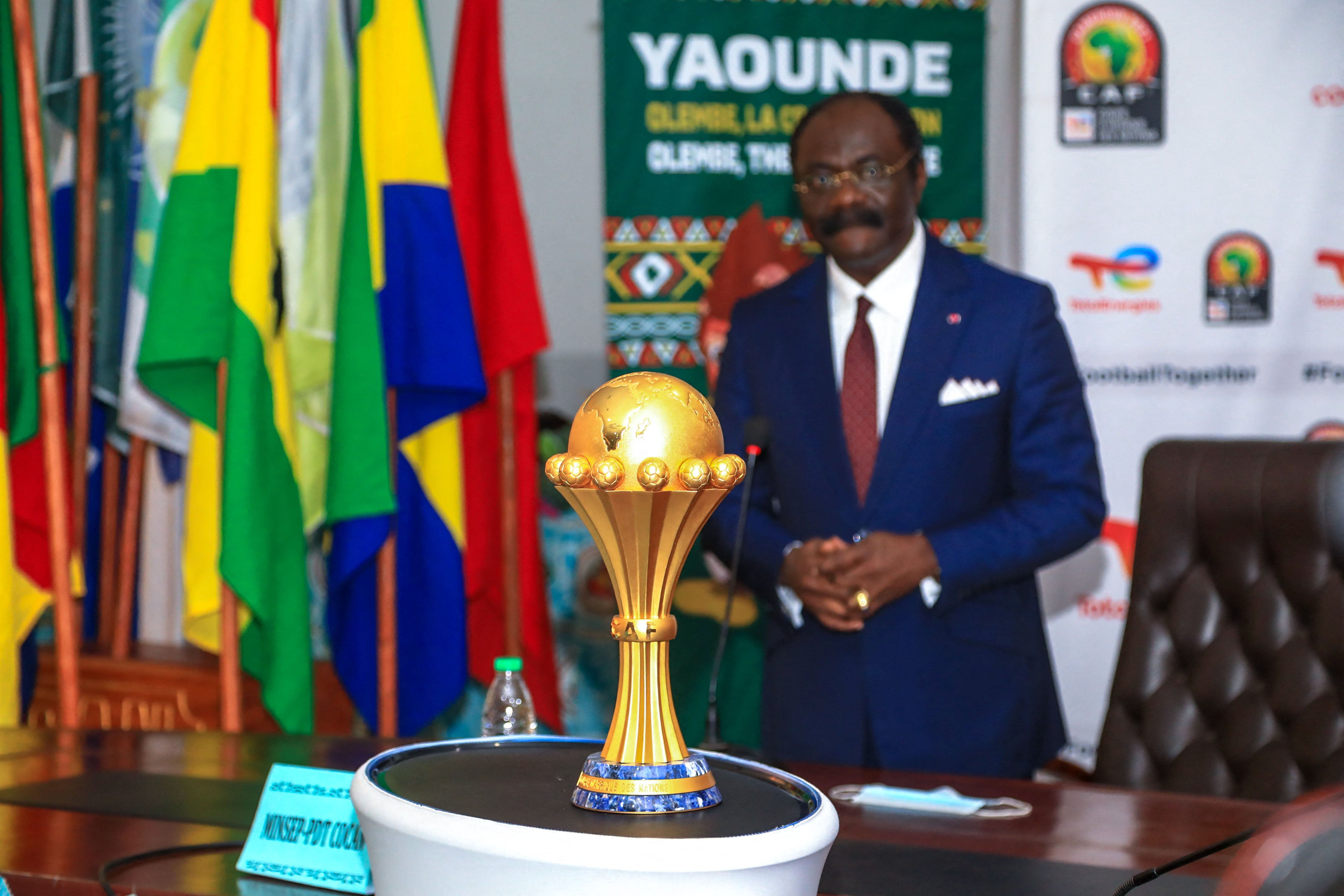 A man stands behind a gold trophy