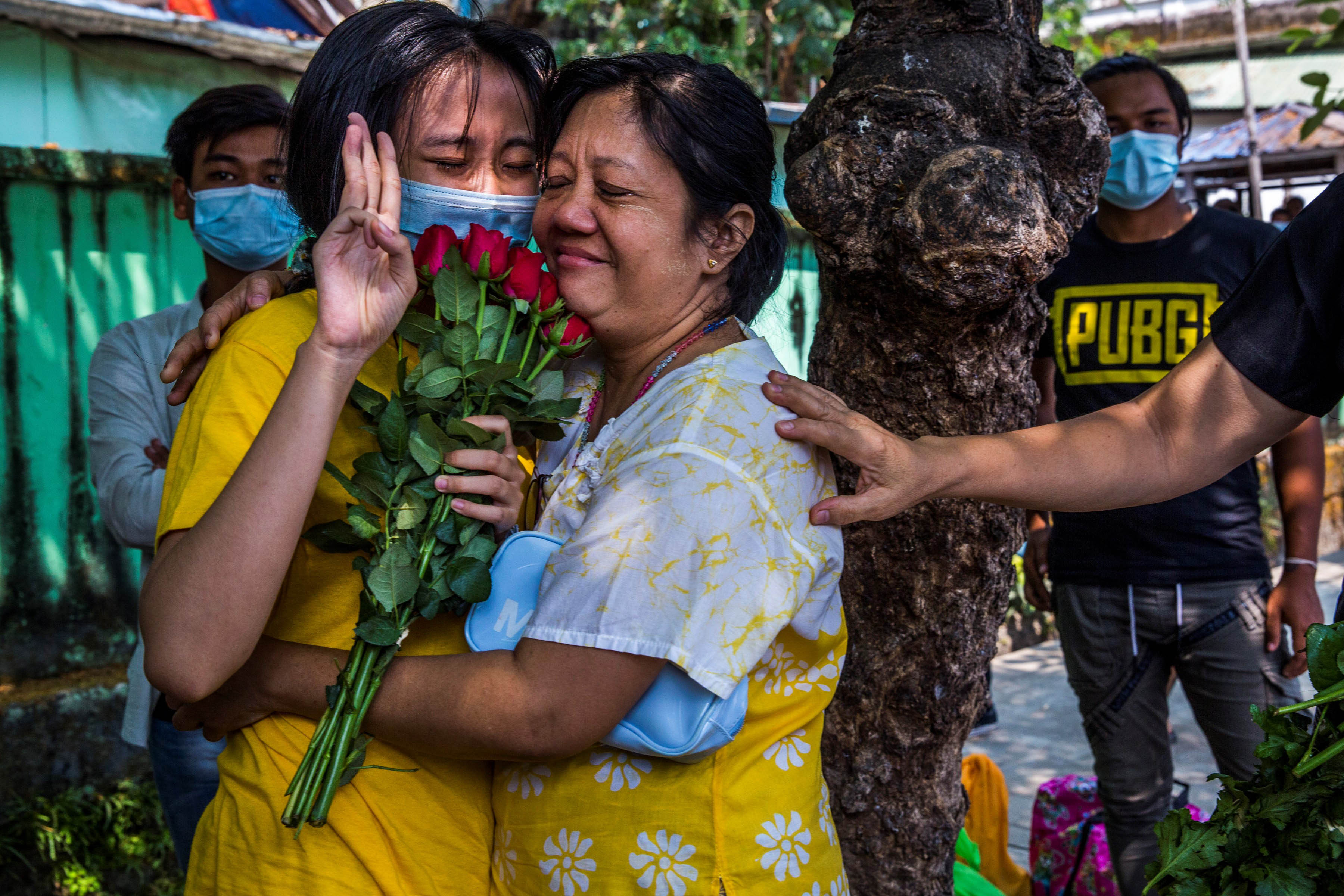 A woman holds up a three finger salute