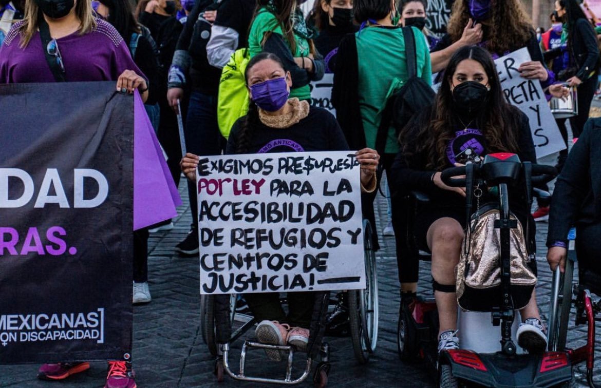 A group of women with disabilities hold a sign