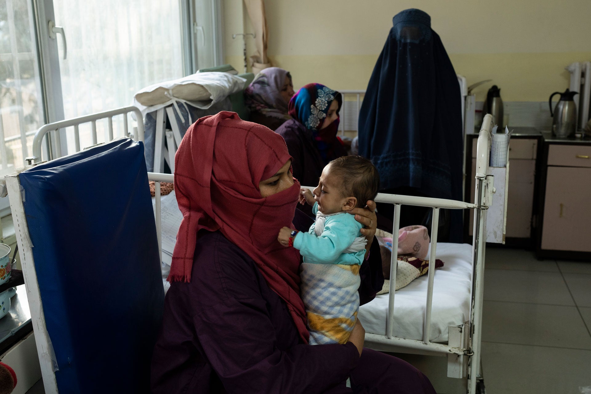 A woman holds her baby in a hospital room
