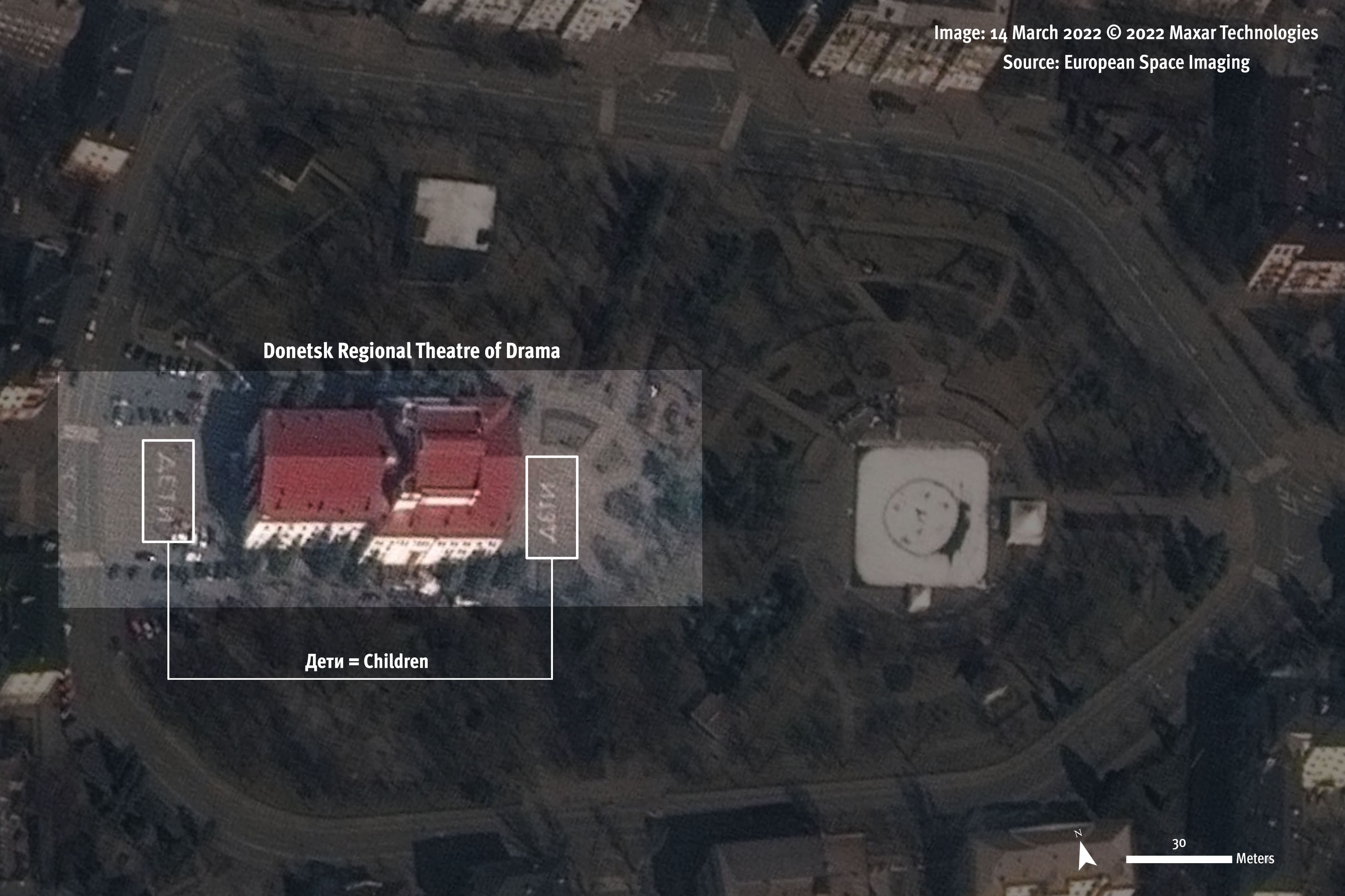 Image satellite enregistrée le 14 mars 2022, montrant le Théâtre dramatique régional de Donetsk à Marioupol, en Ukraine. Le mot russe дети ("enfants") était inscrit par terre en énormes lettres (caractères cyrilliques), des deux côtés de l'immeuble, devant celui-ci et à l’arrière, afin d’être clairement visible pour les forces russes.