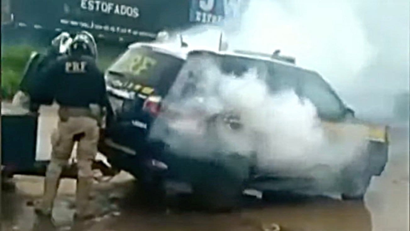 Screengrab from a video shows smoke coming out of a police vehicle