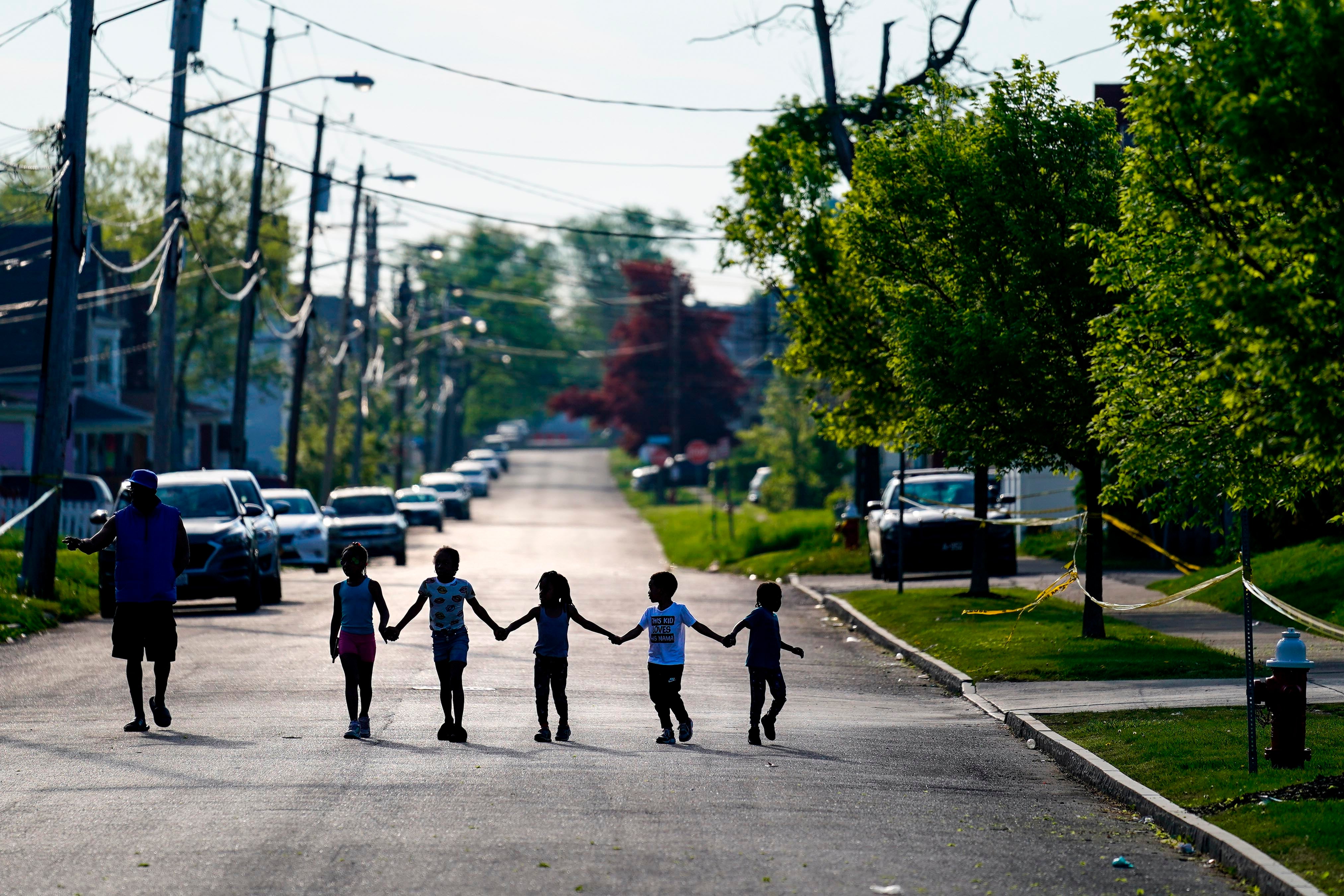 Children walk hand in hand down a street