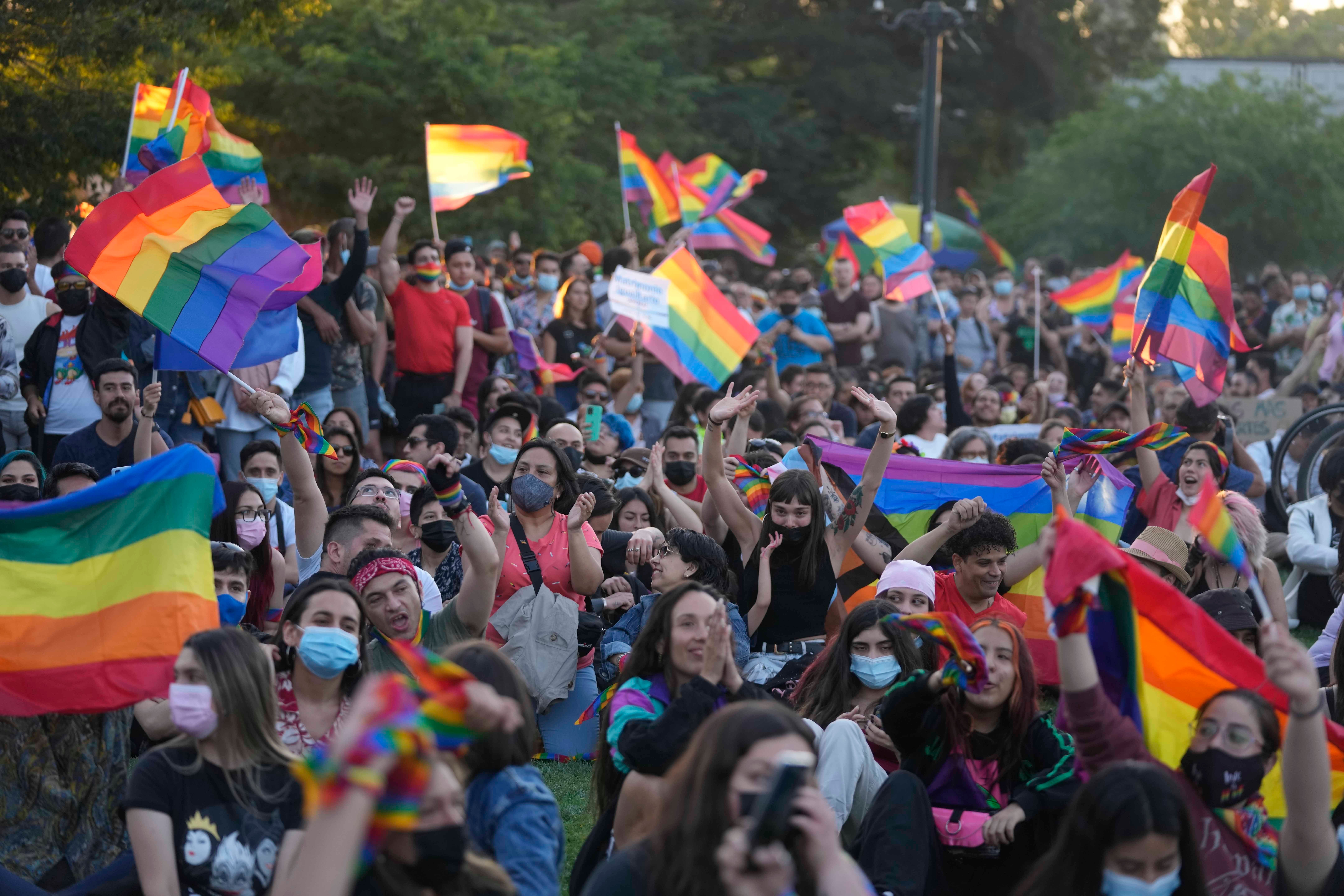 Chileans celebrate after lawmakers passed legislation legalizing marriage for same-sex couples, in Santiago, Chile, Tuesday, Dec. 7, 2021. (AP Photo/Esteban Felix).