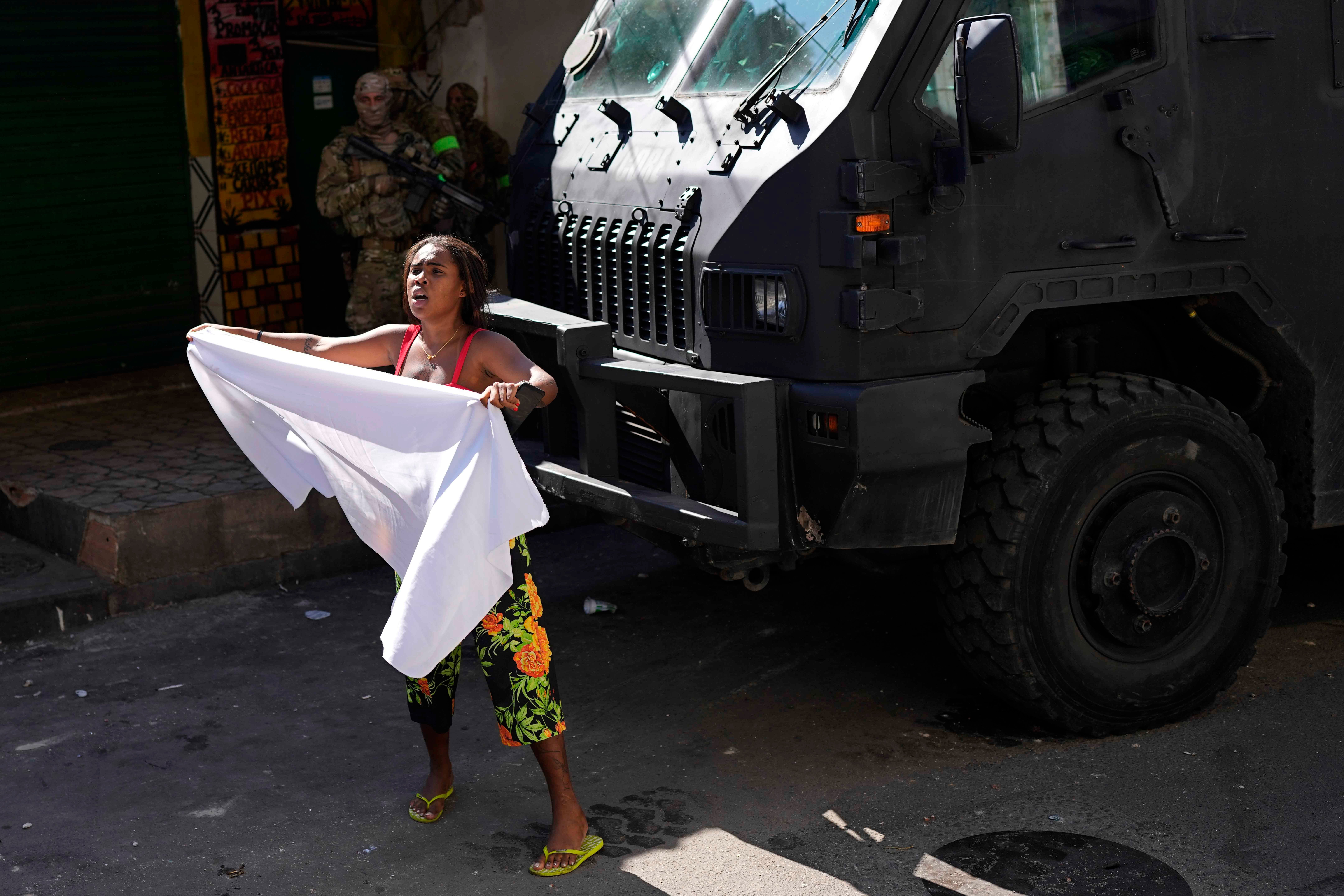 A resident waves a white sheet in protest and to ask for peace after a police operation that resulted in multiple deaths, in the Complexo do Alemao favela in Rio de Janeiro, Brazil, July 21, 2022. 