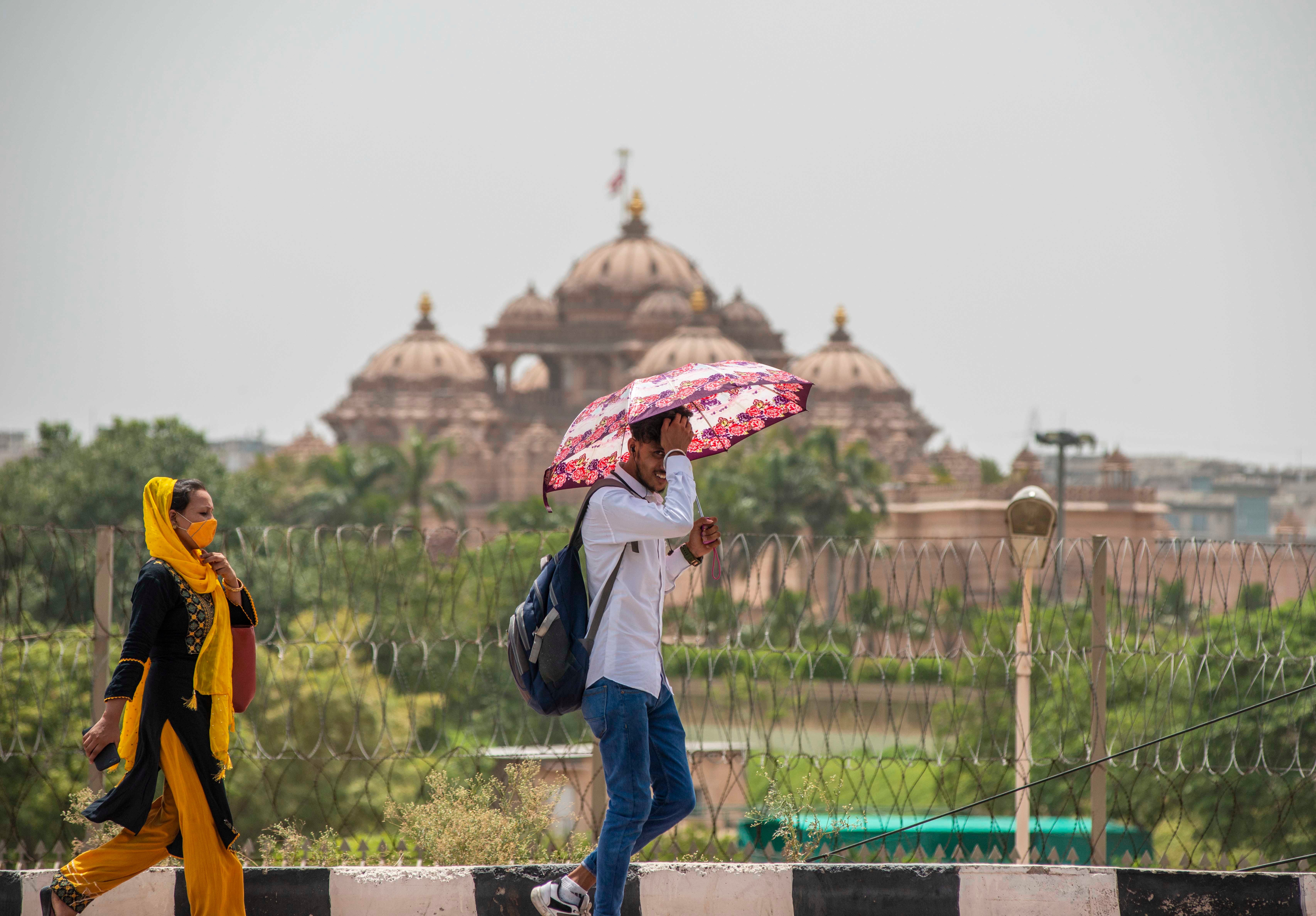 A man shields himself from the sun with an umbrella