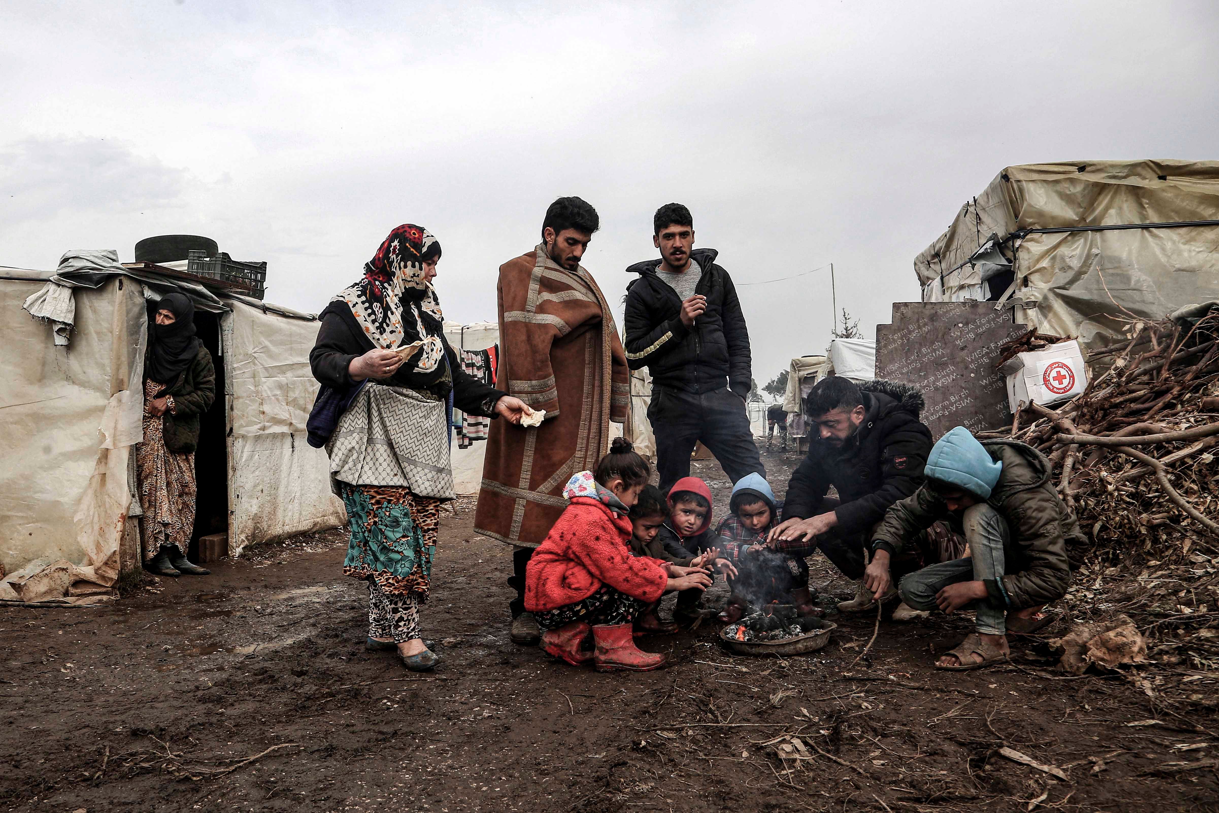 A group gathers around a small fire