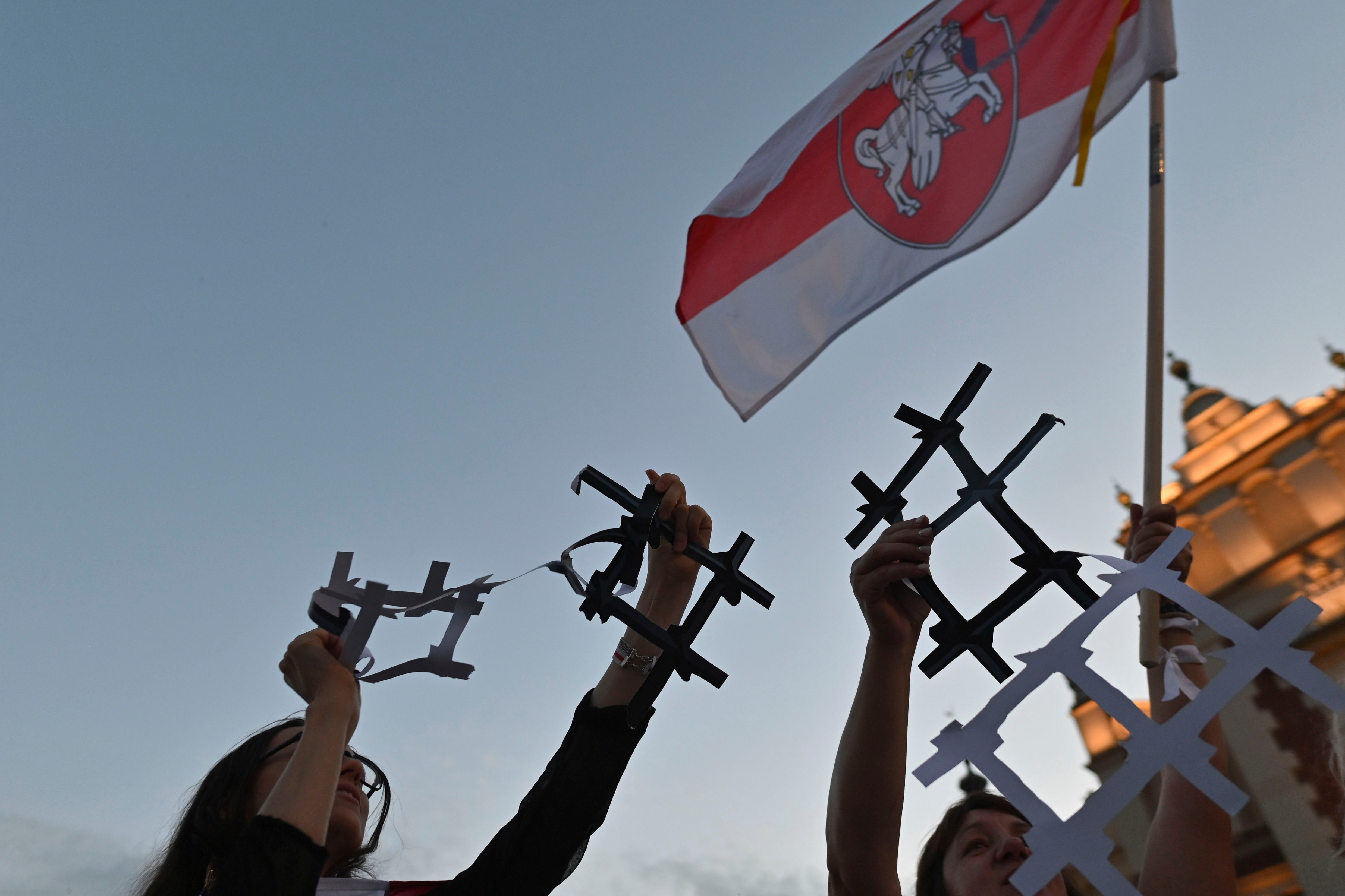Protesters display broken paper prison bars representing the Belarusian population in prisons and the lack of freedom in Belarus, in Krakow, Poland on August 9, 2022. 