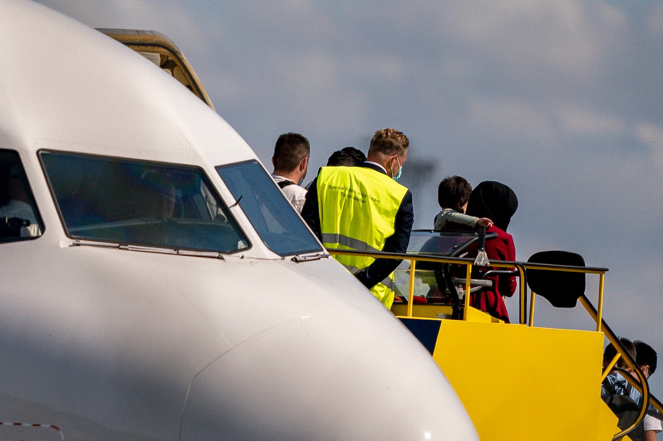 An Afghan woman carries a child as she disembarks at Copenhagen Airport.