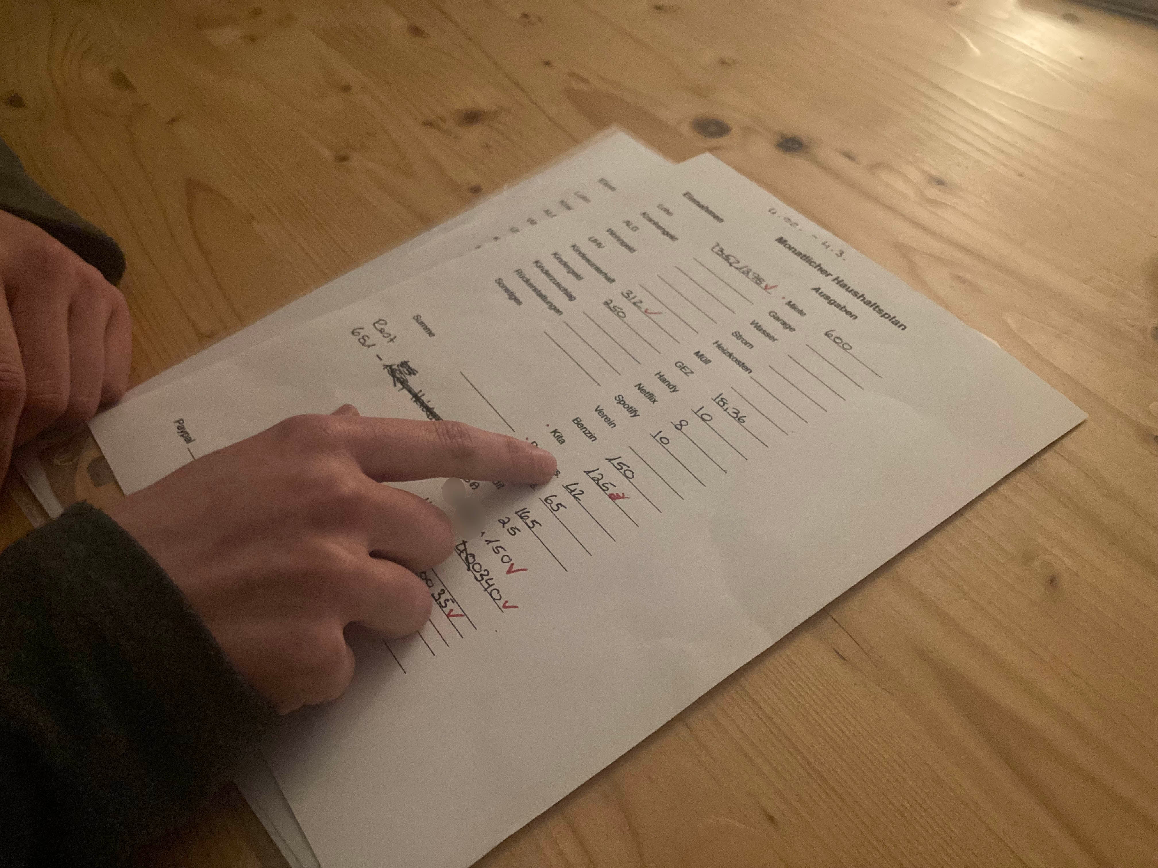 A woman calculates expenses on a sheet of paper