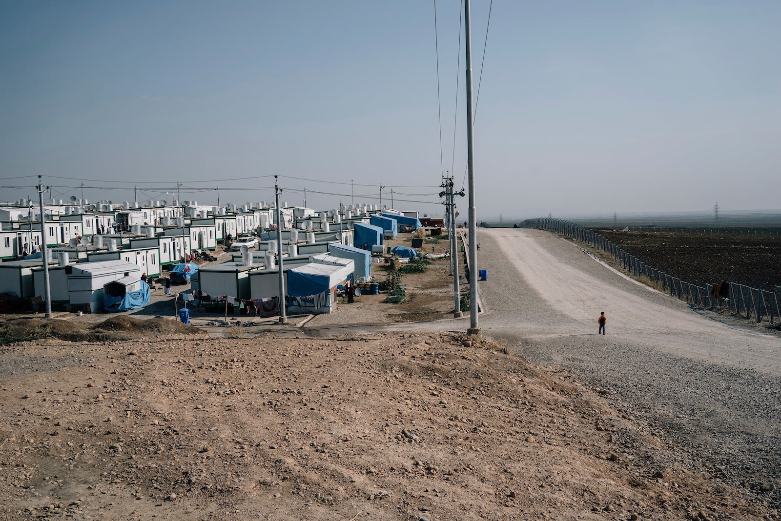 A boy walks on a road at the Mamrashan camp for civilians displaced by war, located a half hour's drive from Dohuk city in Iraq.