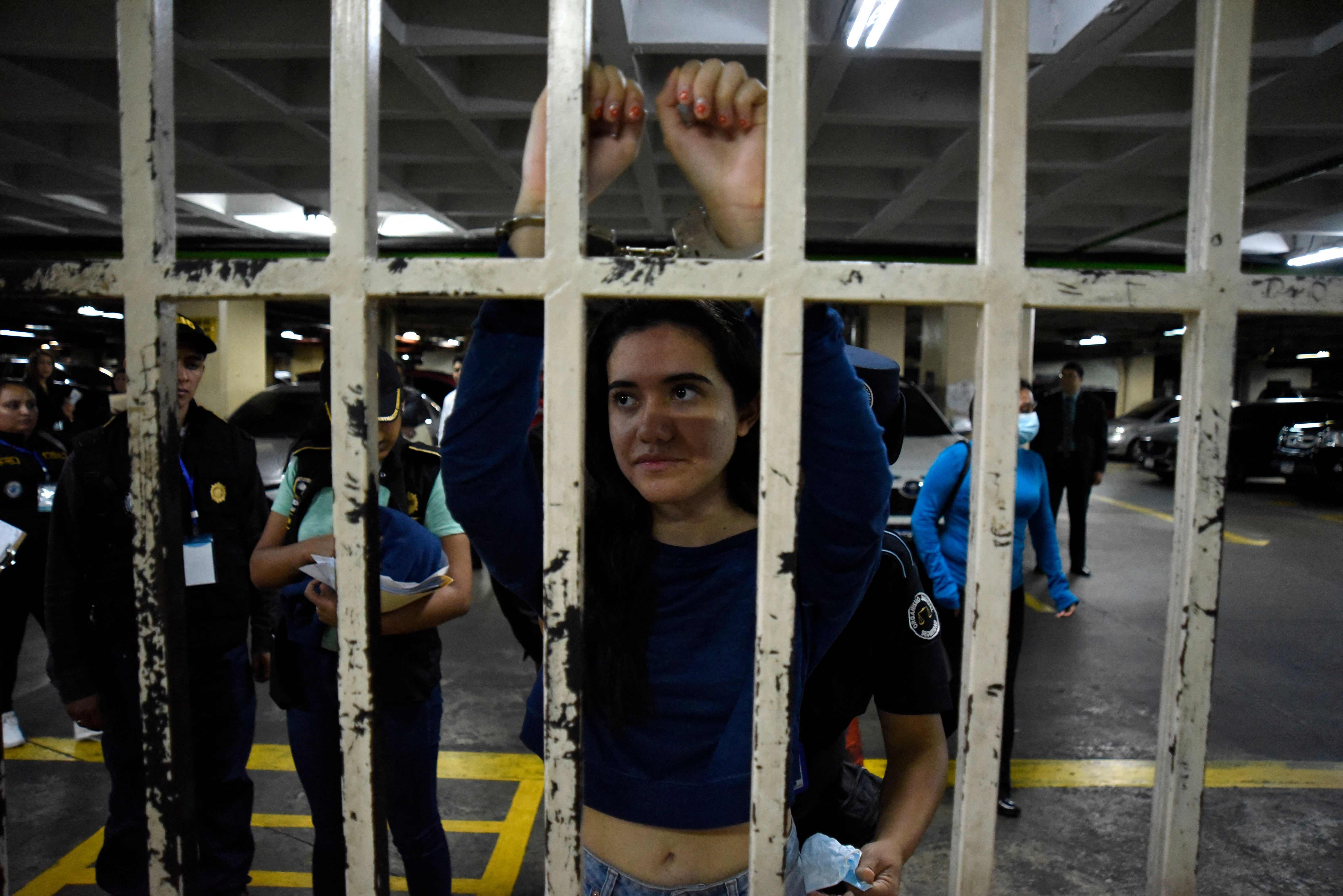 Marcela Blanco (C), a member of the Semilla Party, arrives handcuffed for a hearing at the Palace of Justice after being arrested at her home in Guatemala City on November 16, 2023.