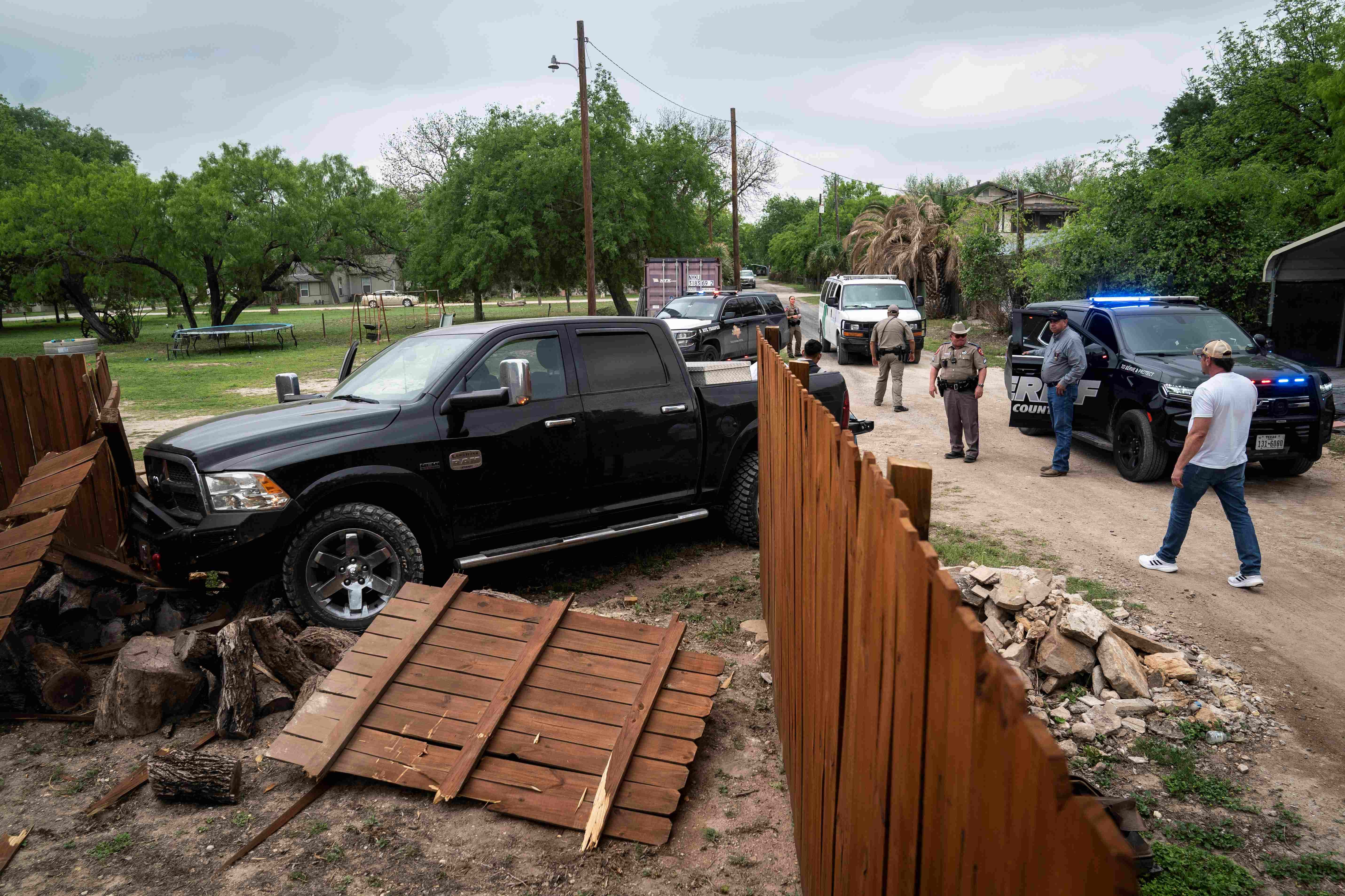 A truck shown after crashing through a wood fence 