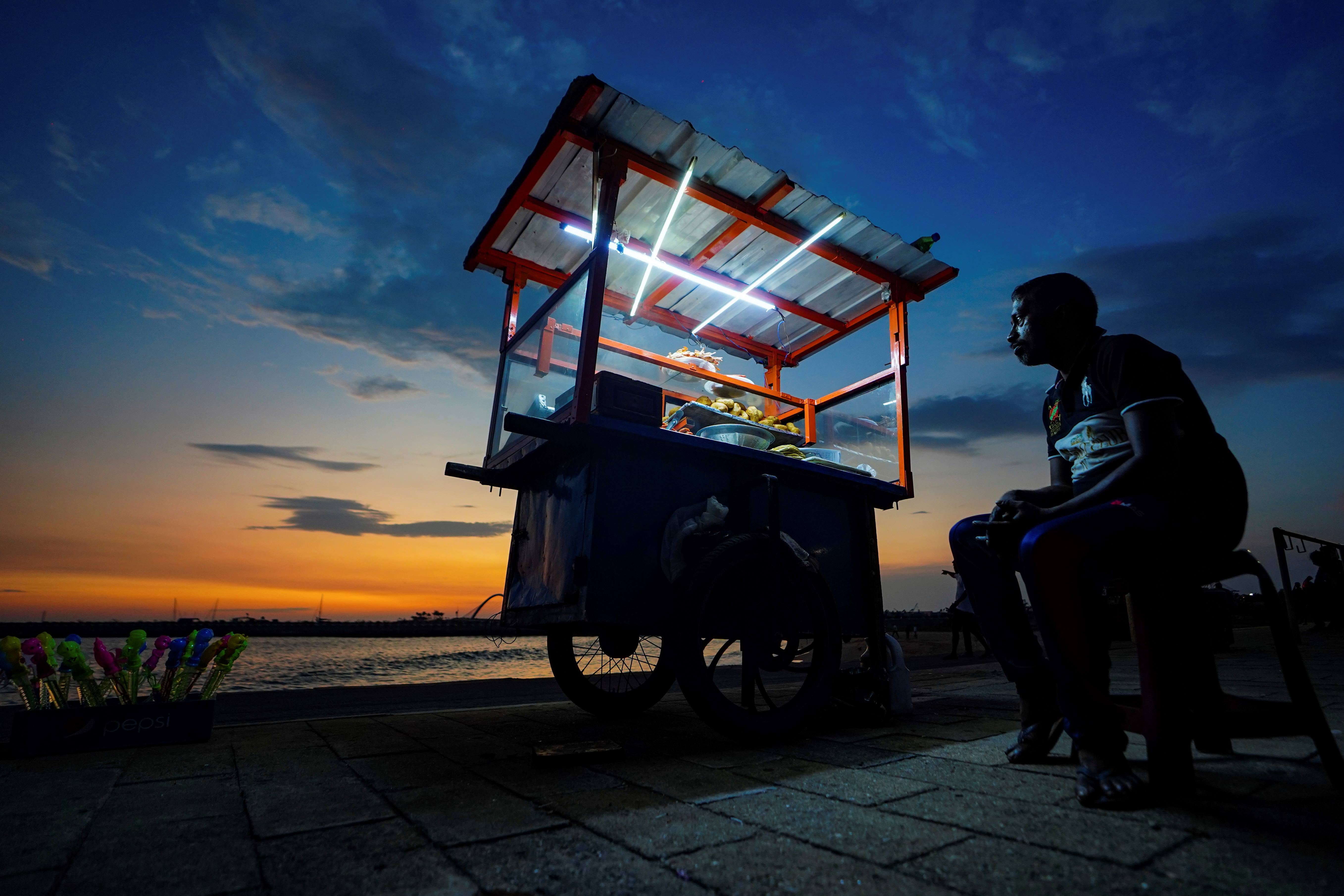A street food vendor awaits customers at the Galle Face promenade in Colombo, Sri Lanka, April 9, 2023. 