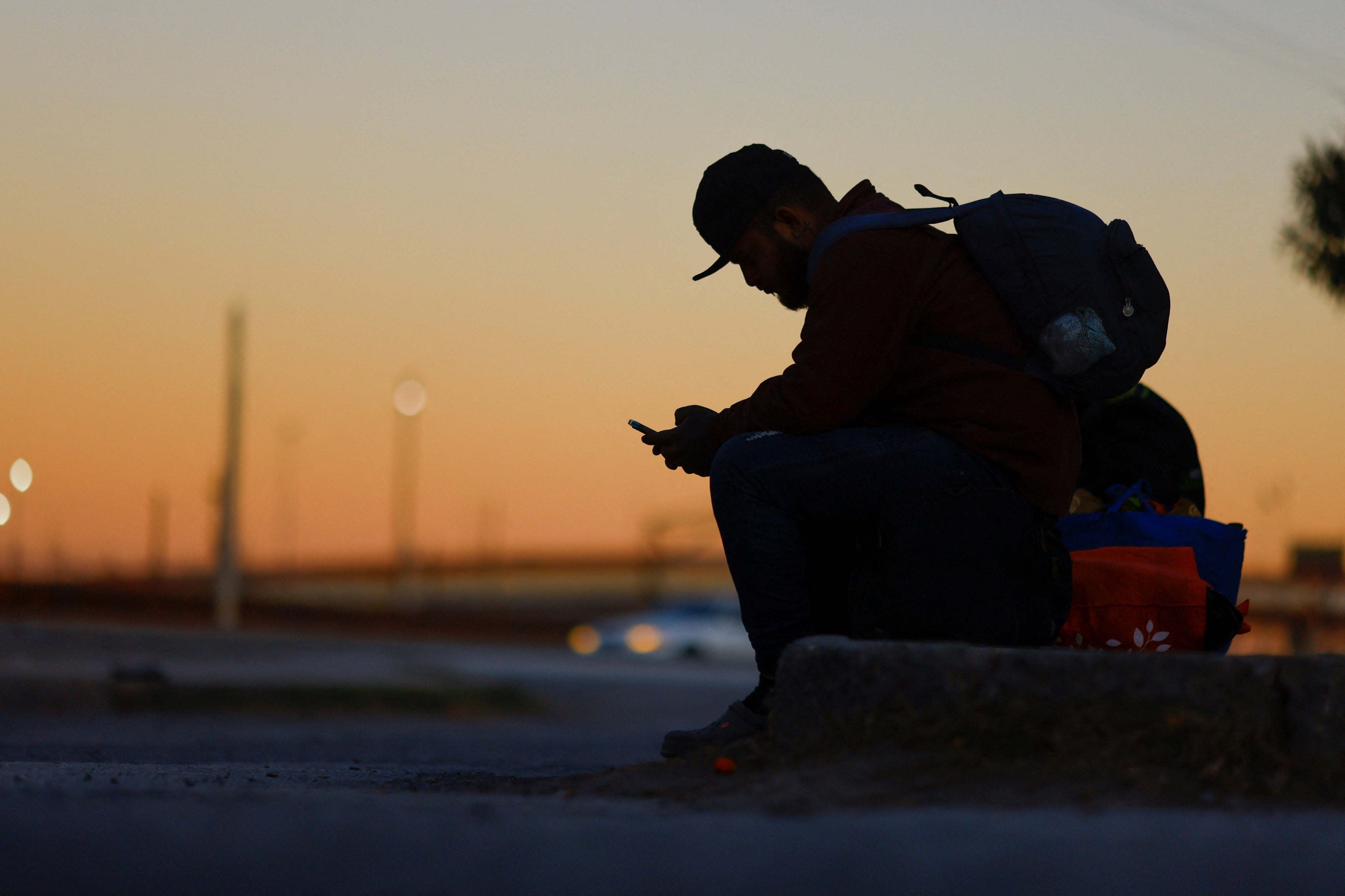 A seated man using a cell phone