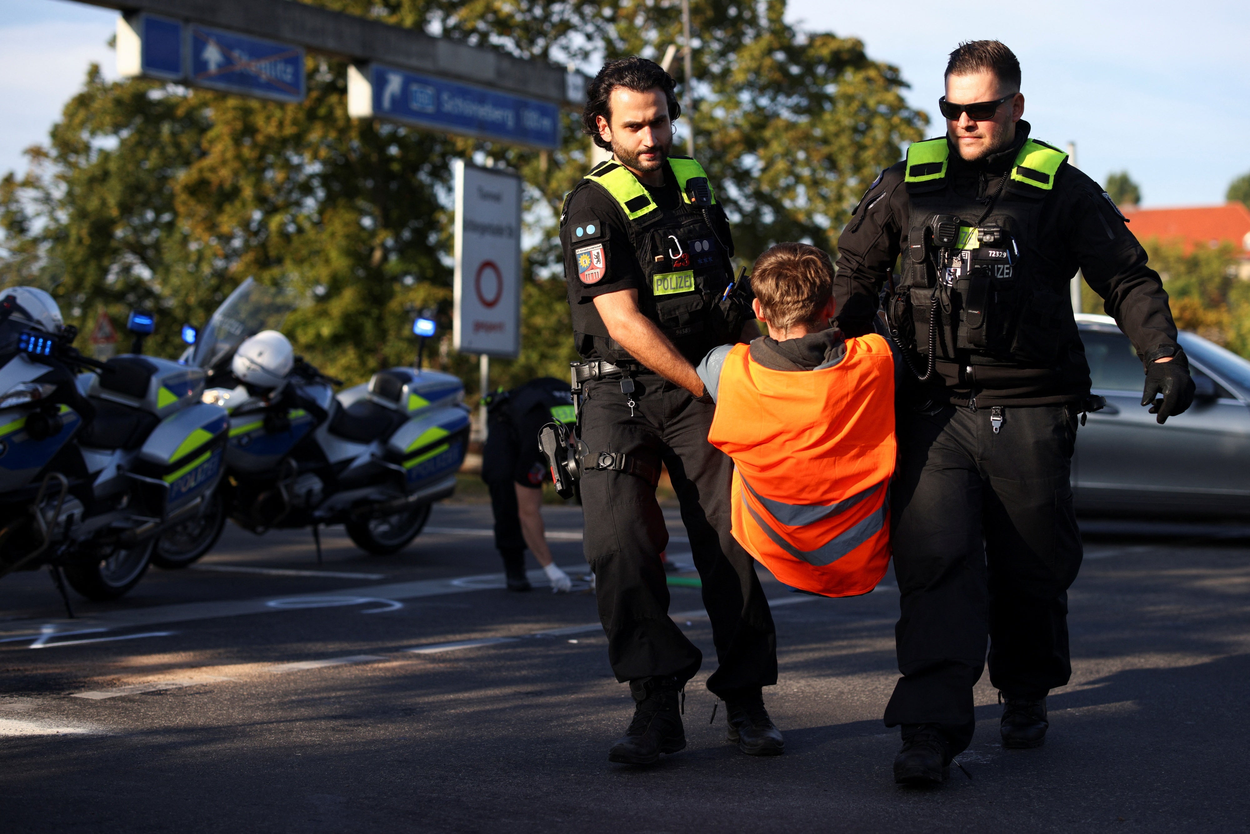Police officers remove an activist of the "Letzte Generation" as they protest for climate action in Berlin, Germany September 28, 2023. 