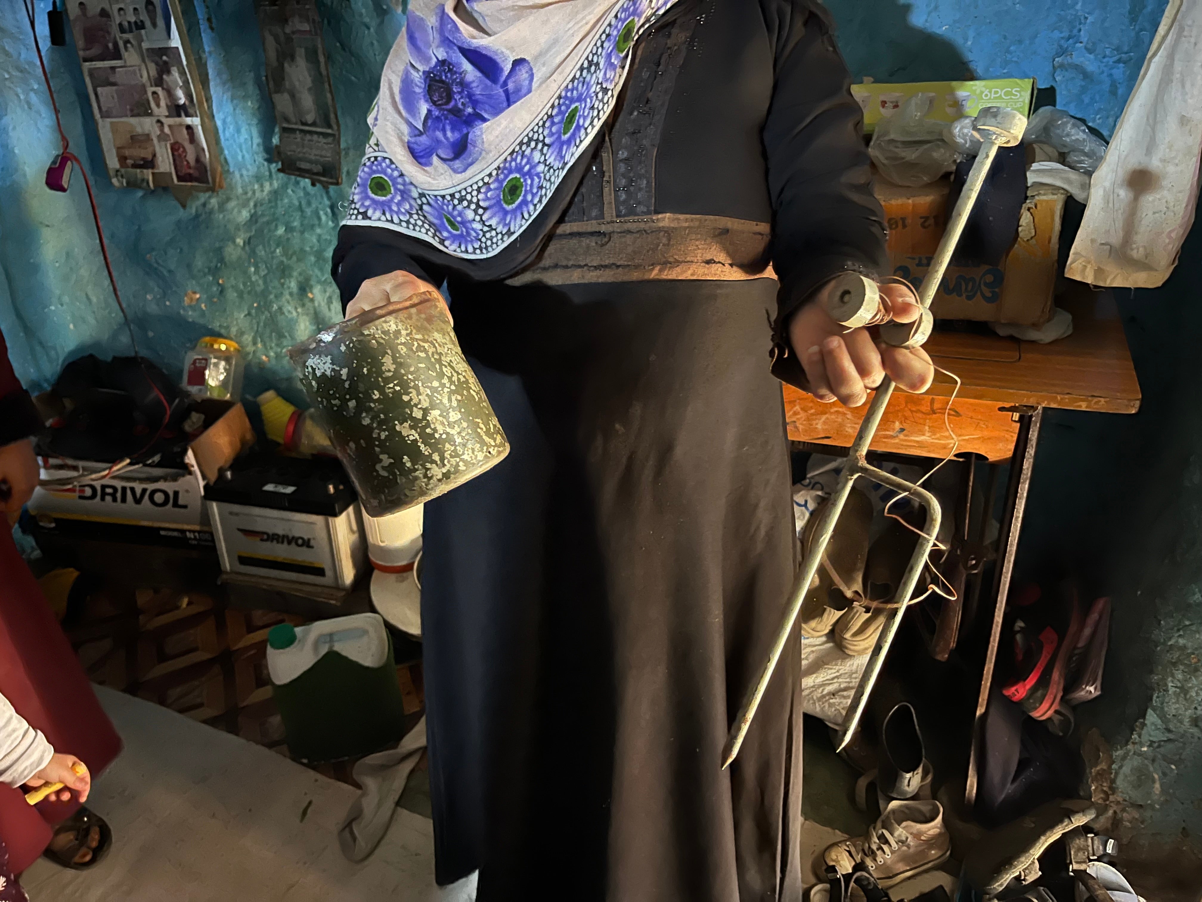 A woman holds up remnants of the landmine that killed her father, Al-Shaqb, Yemen, April 27, 2024.