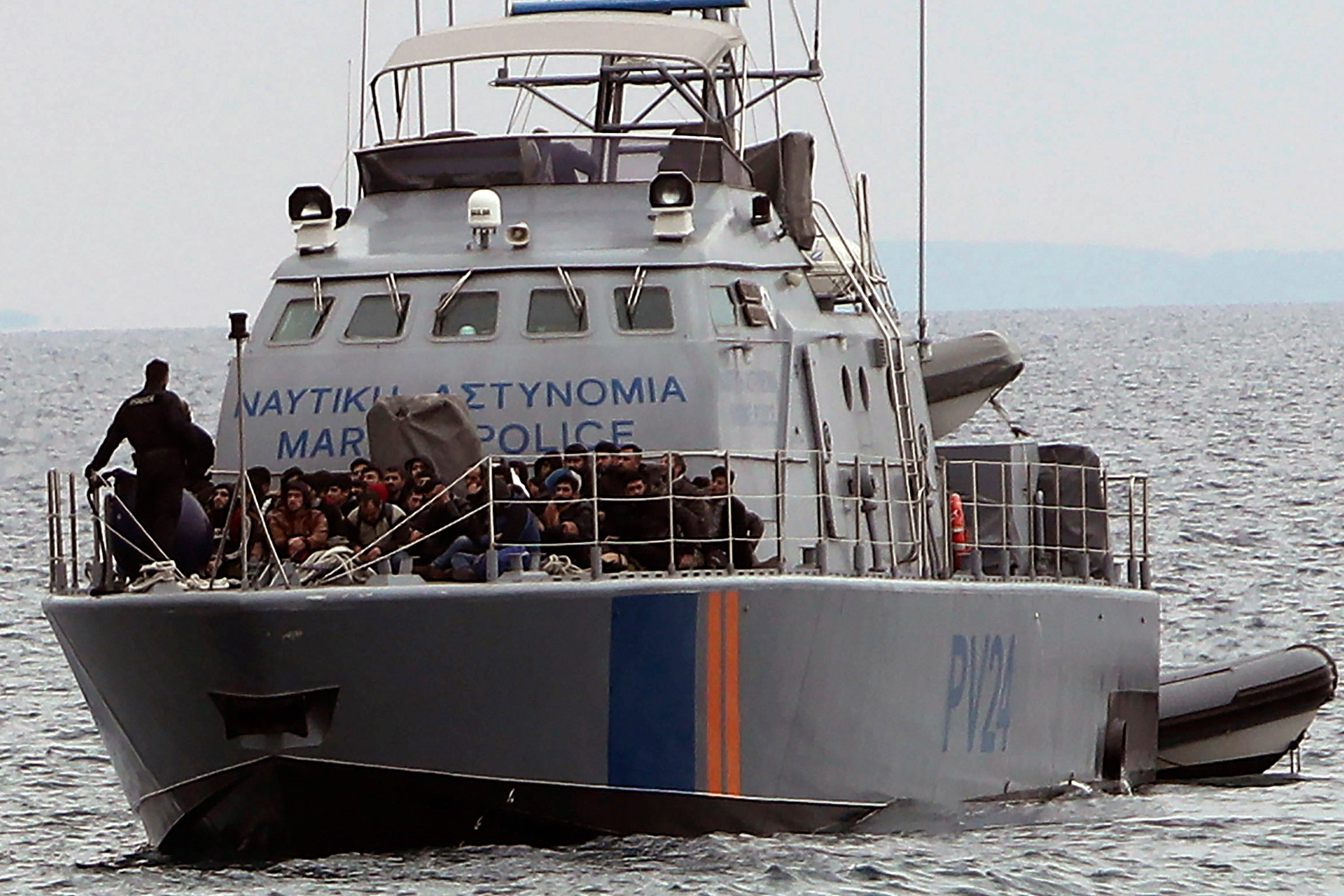 Migrants aboard a police patrol boat at sea