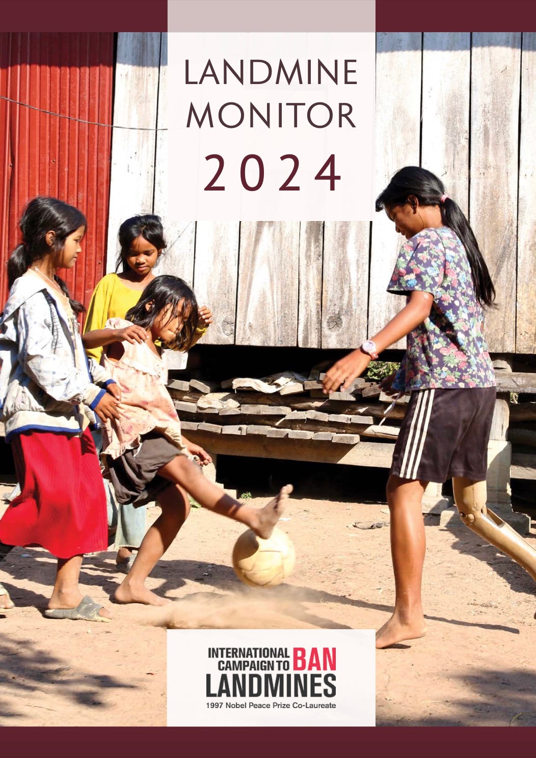 La couverture du « Landmine Monitor 2024 », montrant une jeune fille cambodgienne âgée de 13 ans, jouant au football avec ses sœurs dans la province de Kampong Thom, au Cambodge. 