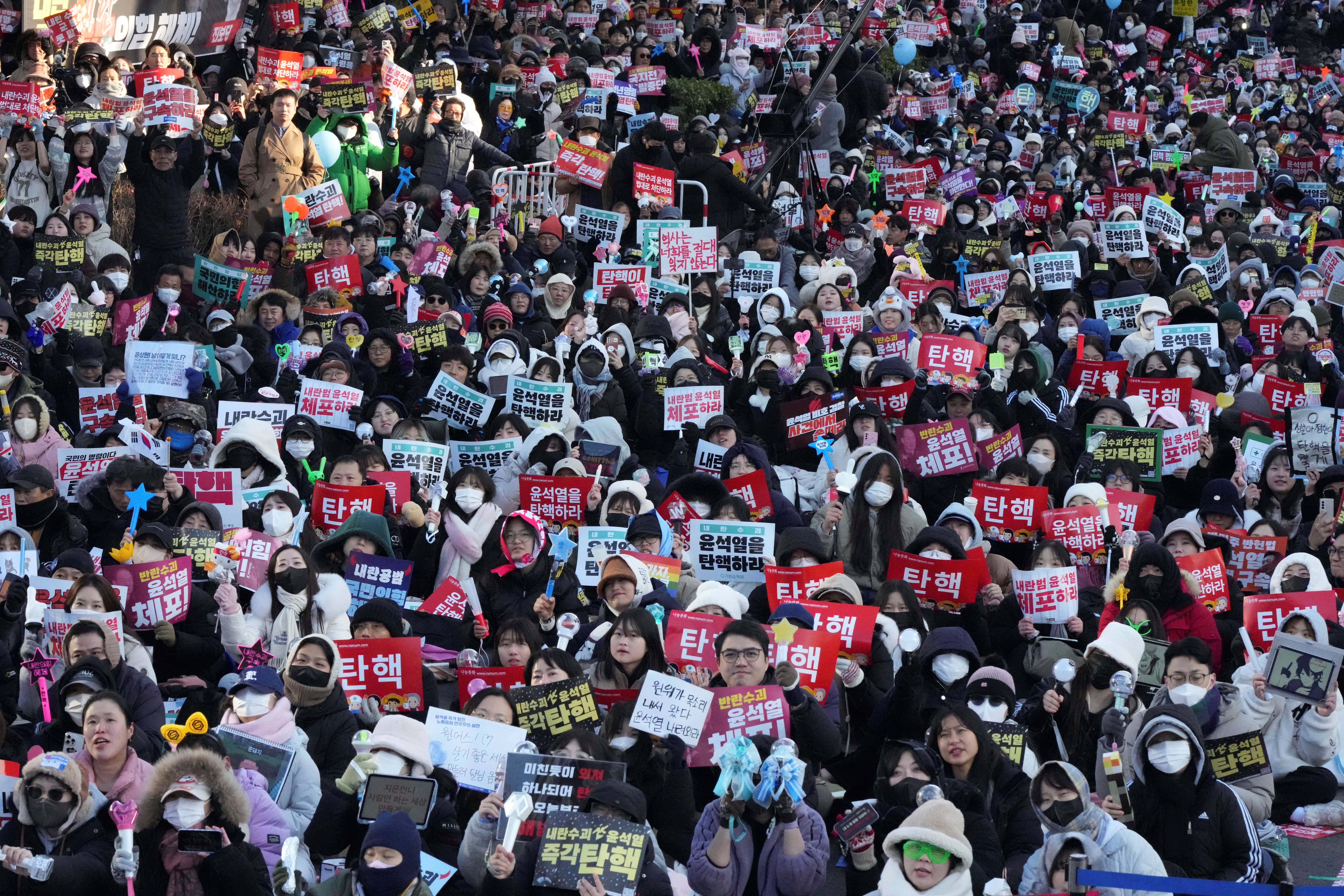 Protesters gather holding banners demanding the impeachment of South Korea's president
