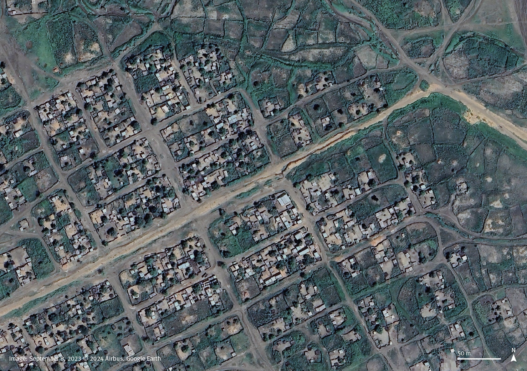 Satellite imagery comparison between September 8, 2023, and November 12, 2024, shows corrugated metal rooftops are missing from the buildings in a residential area in the town of Habila, South Kordofan, Sudan. 