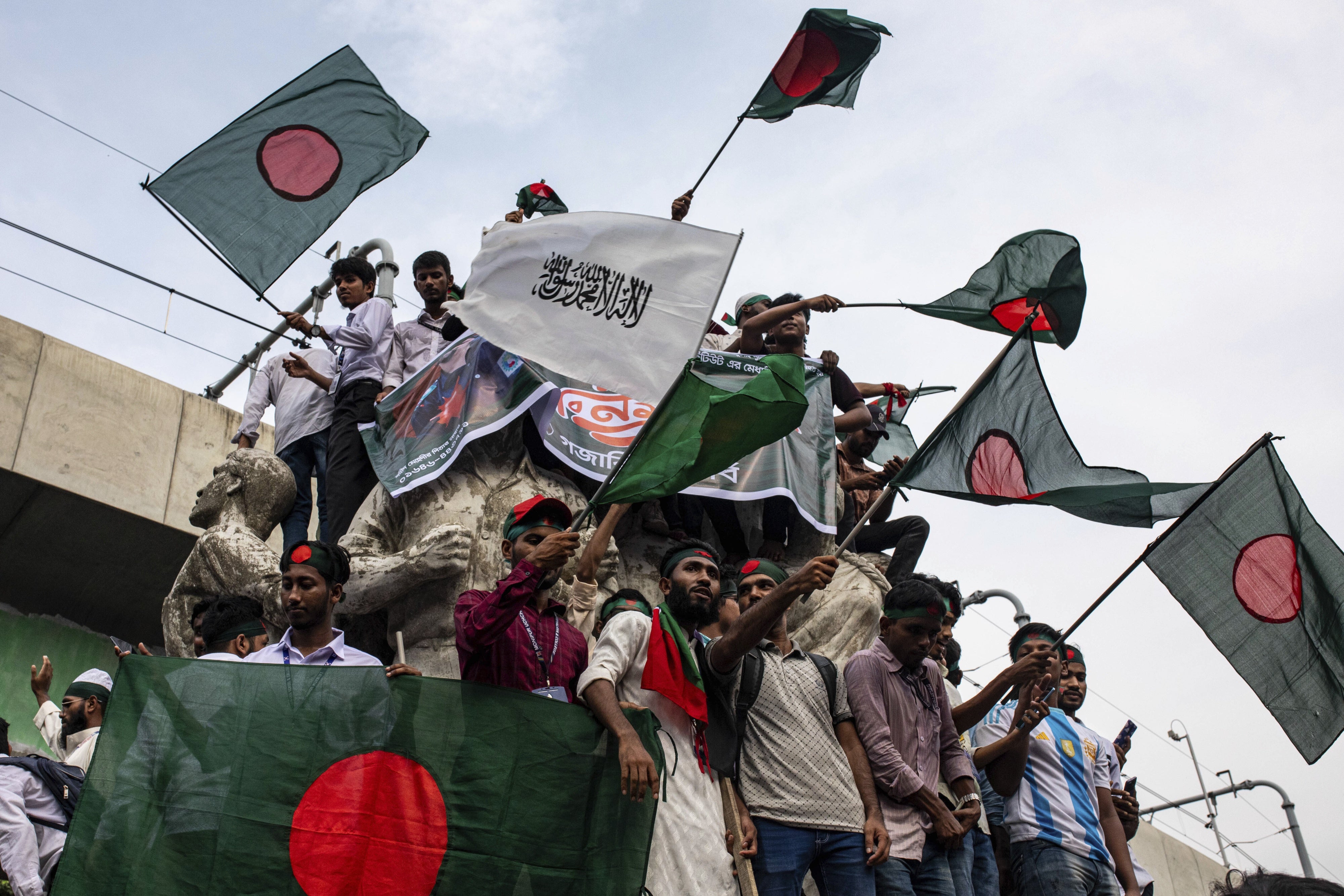 Des Bangladais brandissaient le drapeau national à Dhaka le 5 septembre 2024, un mois après la chute de l'ancienne Première ministre Sheikh Hasina survenue le 5 août 2024, et commémoraient la mort des personnes qui ont été tuées lors des manifestations ayant mené au départ de Sheikh Hasina.