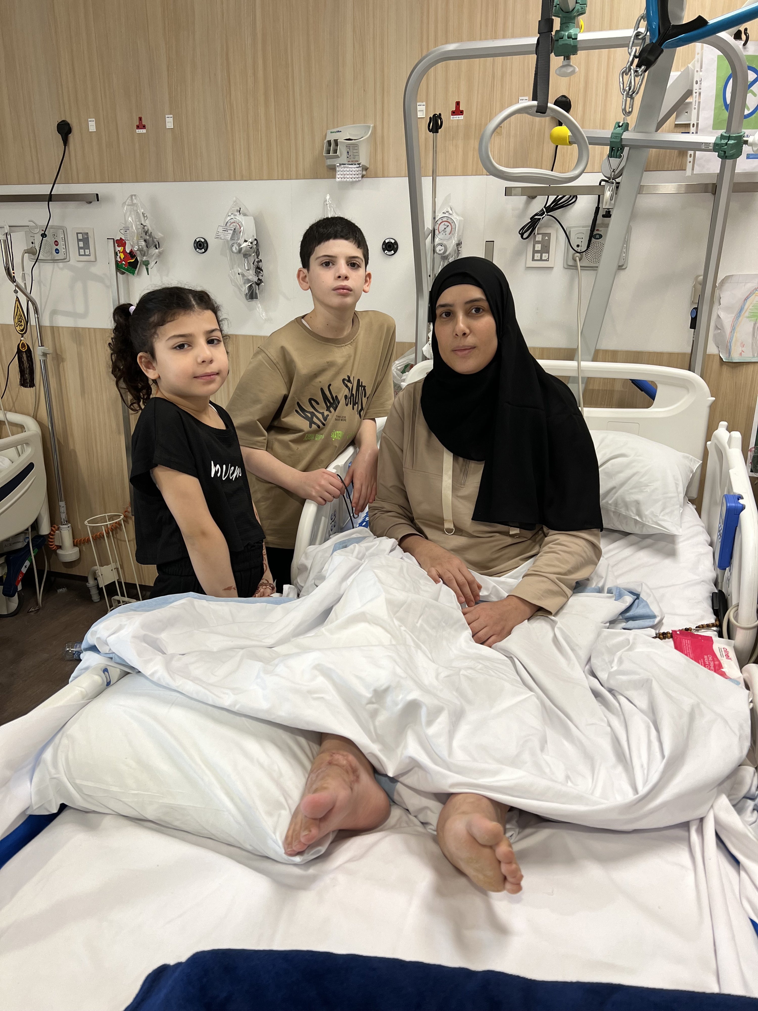 Shaima Abu Jazar (right) with her children Hudaifa (center) and Maryam in a hospital in Doha, Qatar.