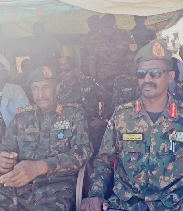 Commander Abu Aqla Keikel (right), bearing the insignia of liwa’ (Major General) on his shoulder, sits next to SAF General Abdelfattah al-Burhan (left), both in SAF uniform. Sudan Shield Forces Facebook page December 23, 2024.