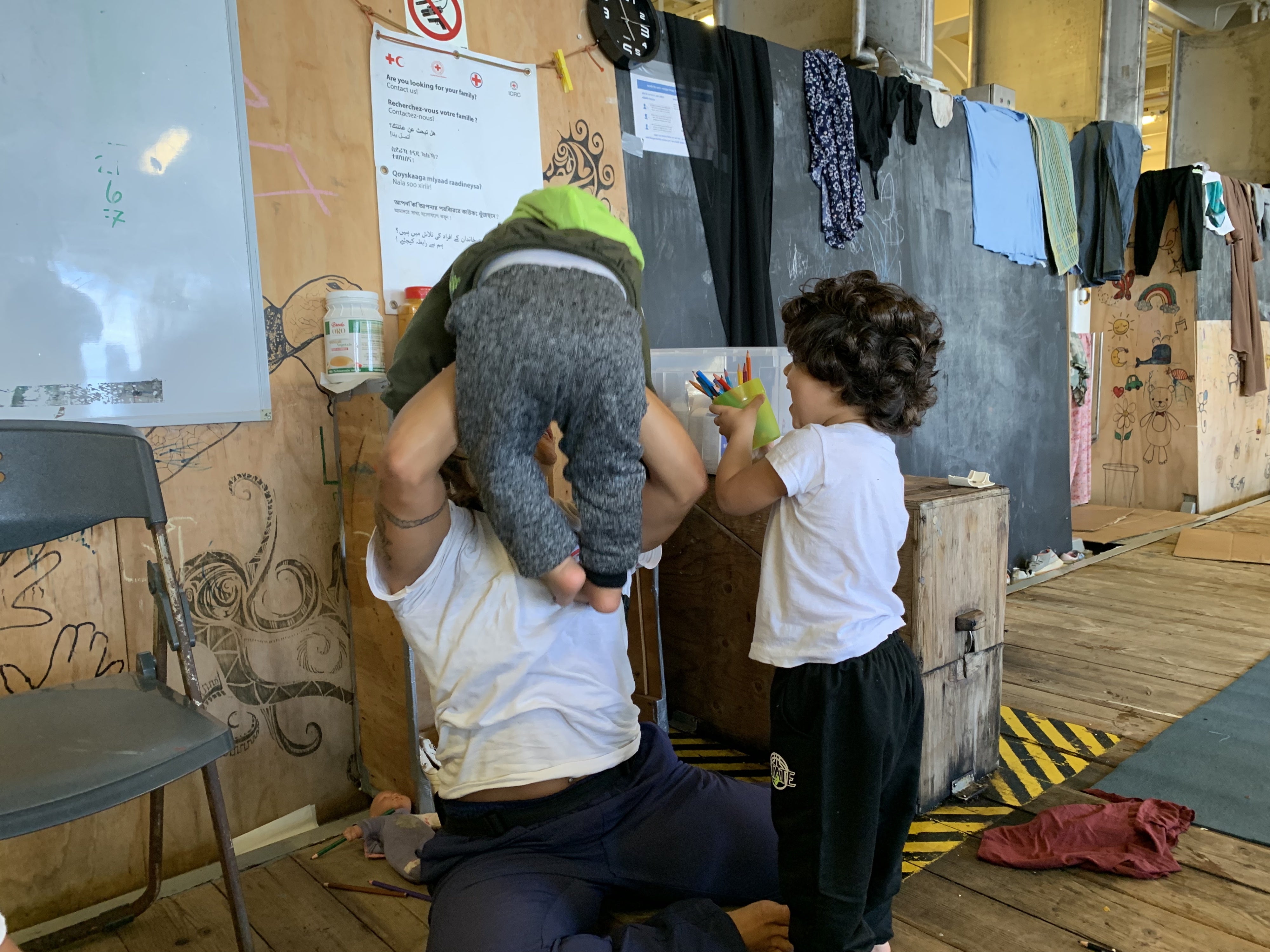 Un membre de l’équipage de MSF jouait avec deux enfants dans une section du Geo Barents hébergeant les femmes rescapées et les enfants, le 21 septembre 2024.