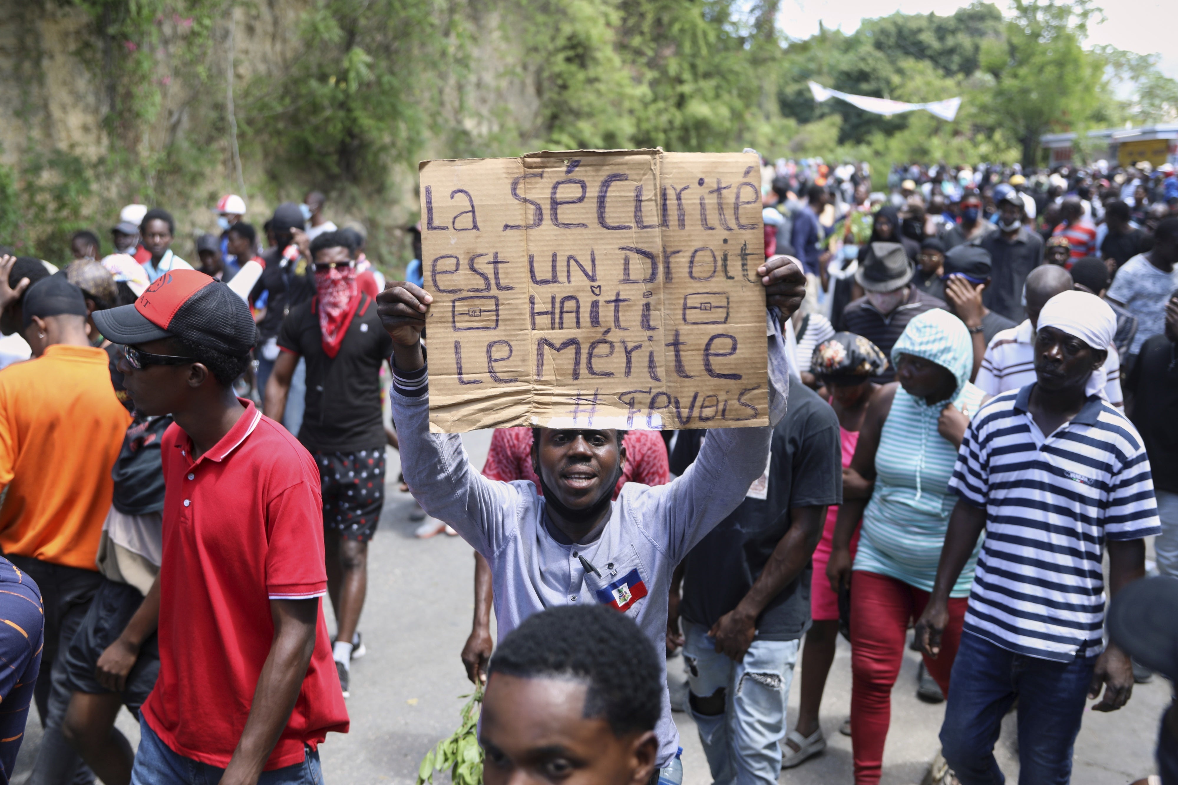 Un manifestant brandissait une pancarte sur laquelle on pouvait lire : « La sécurité est un droit, Haïti le mérite » lors d'une manifestation à Port-au-Prince, en Haïti, le 2 avril 2025.