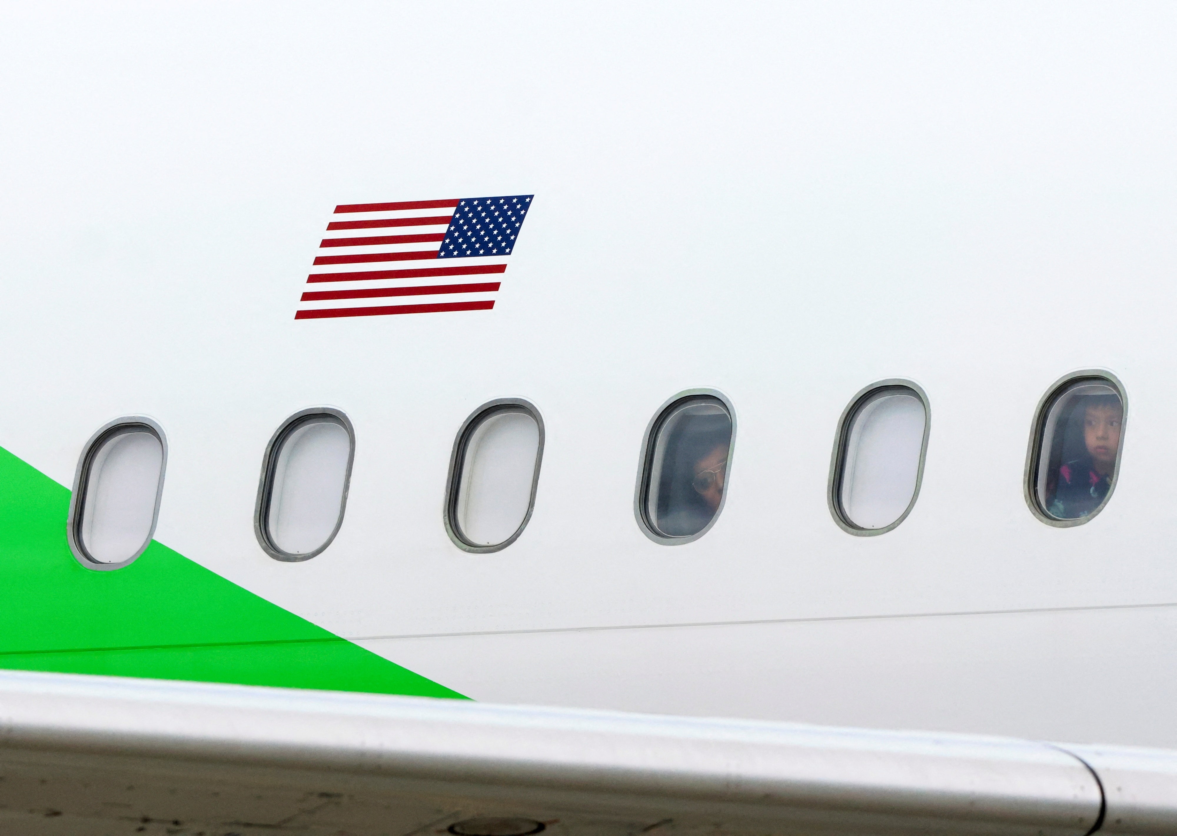 Algunas personas miran por las ventanillas de un avión