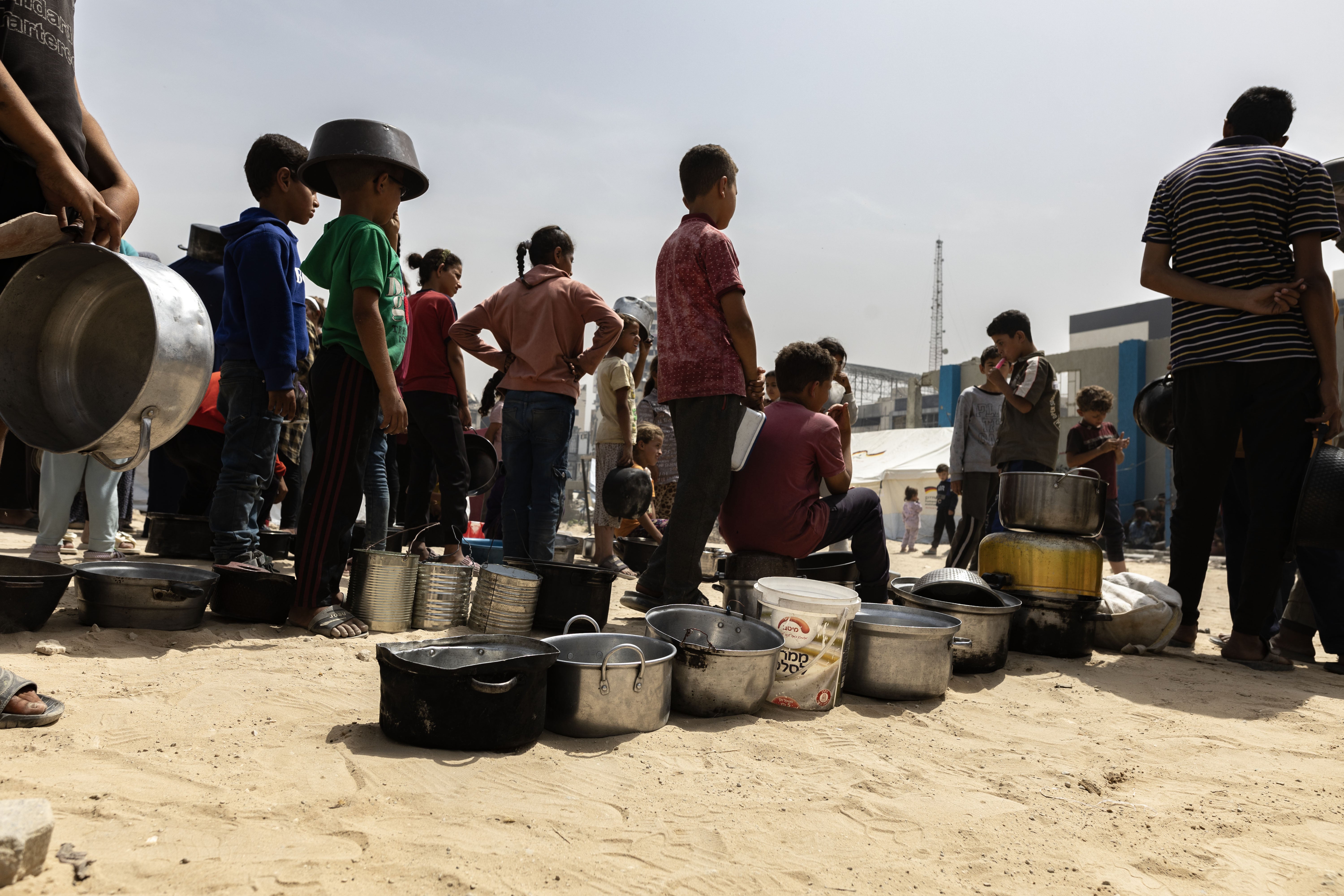 Displaced Palestinians wait to receive a meal in Gaza City, May 17, 2025. 