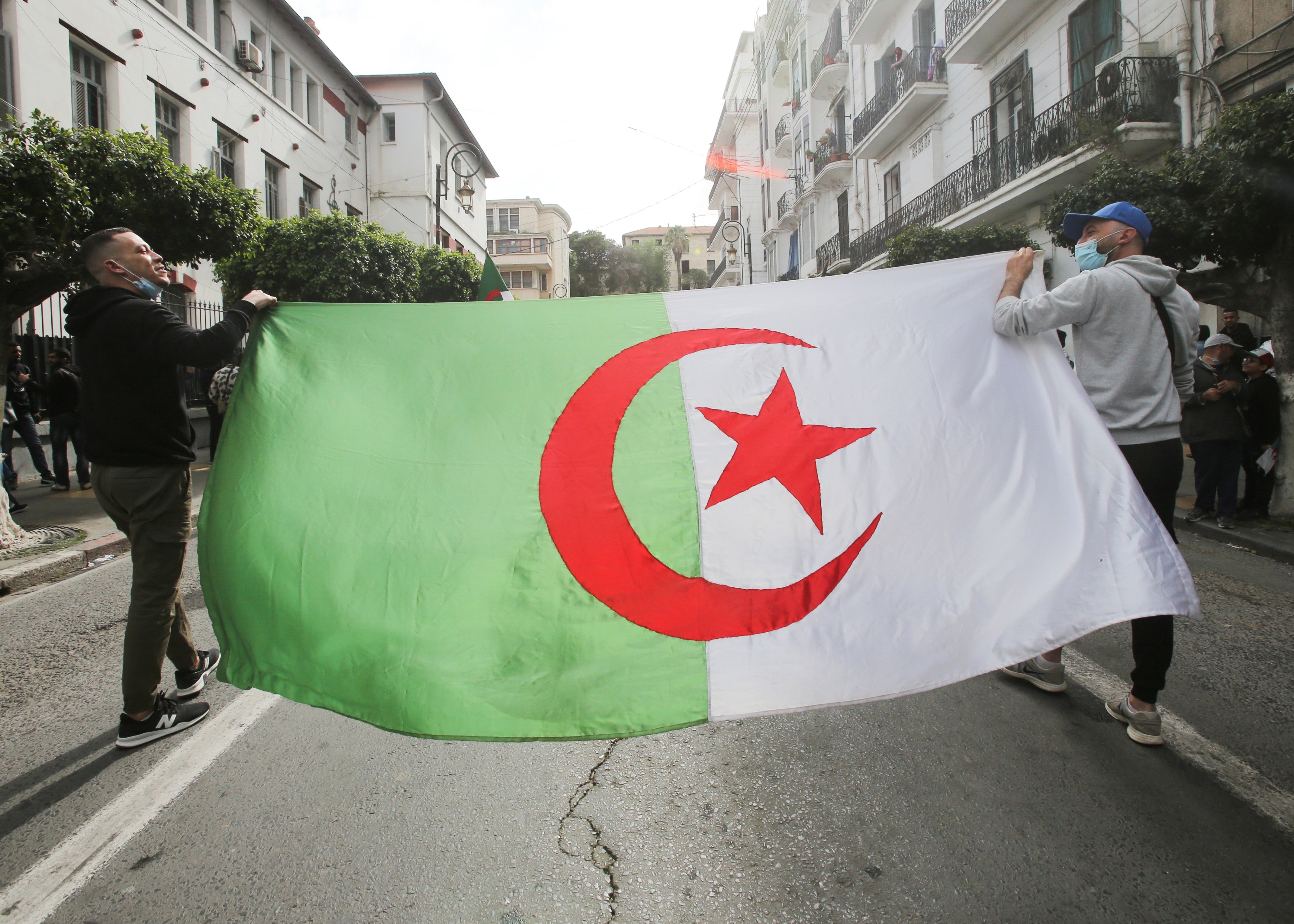 Deux manifestants transportaient un drapeau algérien à Alger, le 2 avril 2021.