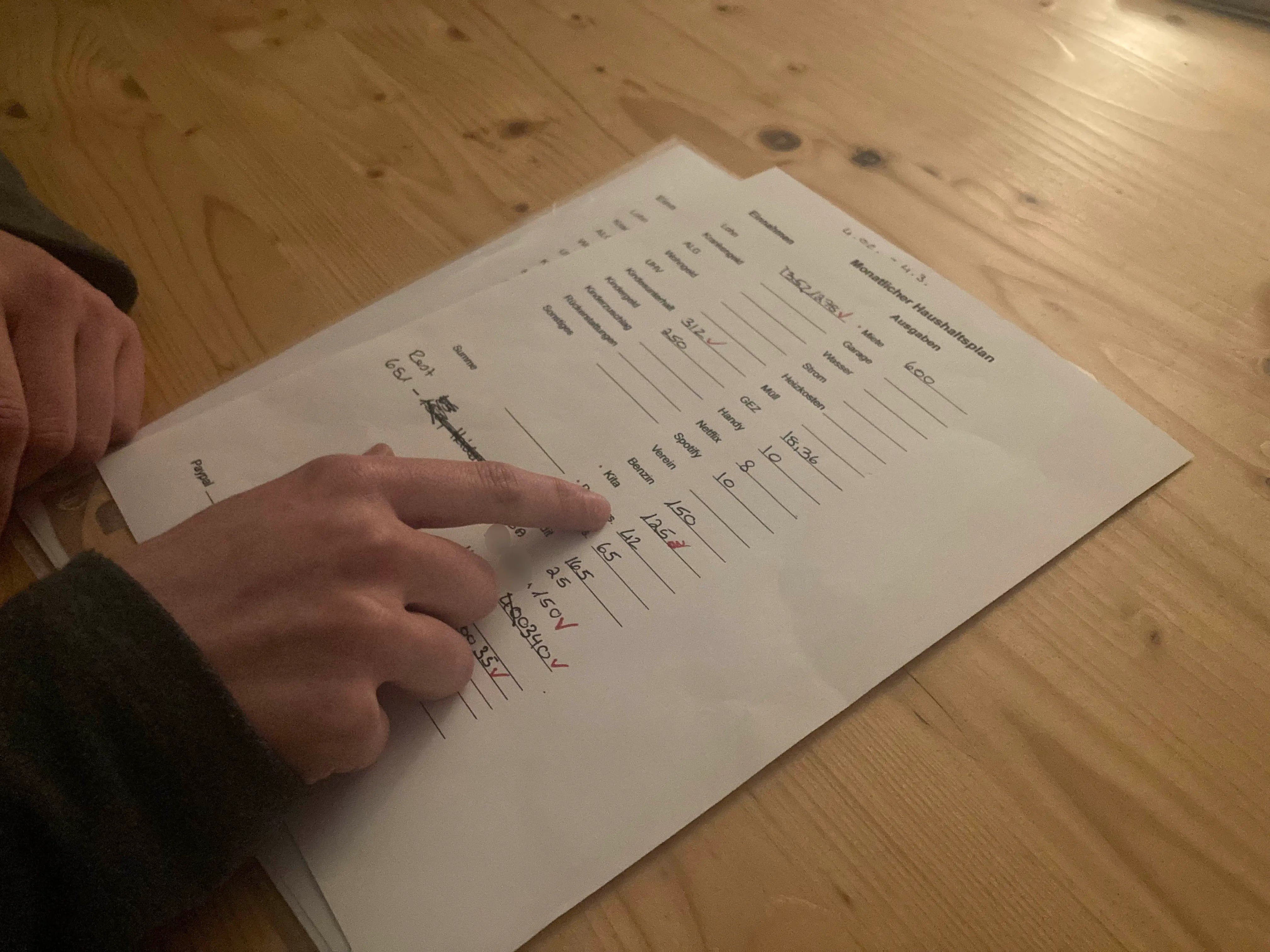 A single mother in low-wage work shows her monthly household budget to Human Rights Watch during an interview, Baden-Württemberg, February 2023.