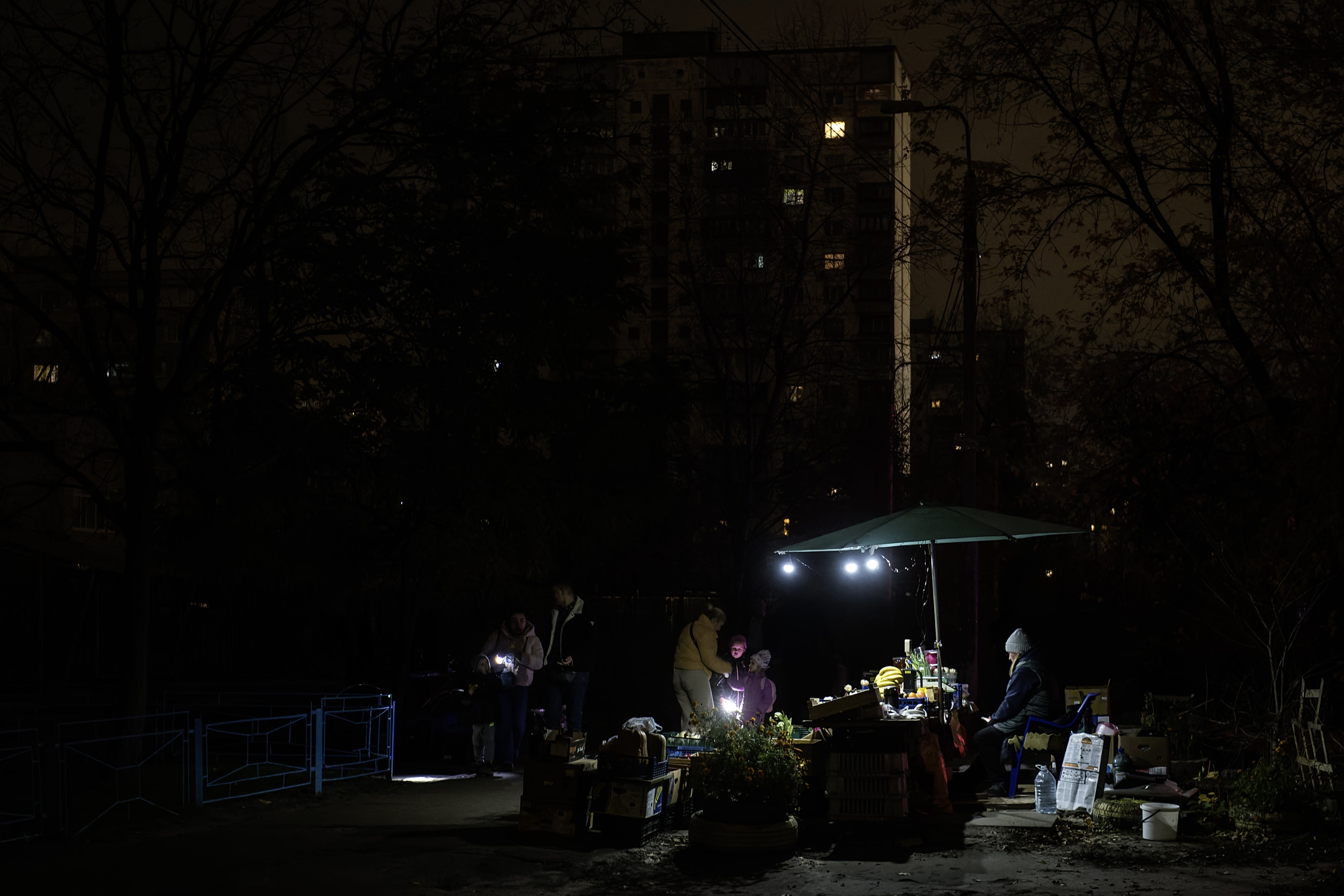 A fruit and vegetable stall in a residential neighborhood is illuminated by small lamps during a blackout caused by Russia’s attacks on Ukraine’s power infrastructure, in Kyiv, Ukraine, on November 6, 2025.