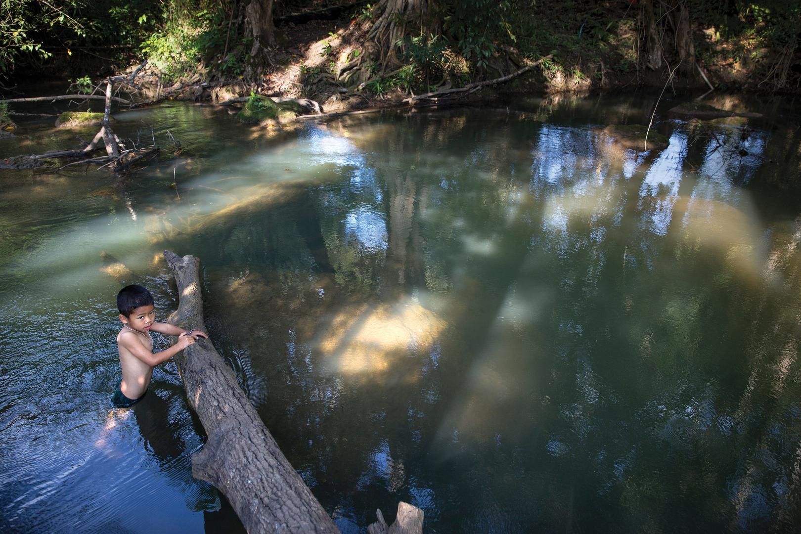 A 7-year-old boy swims in Klity Creek in Kanchanaburi, Thailand. The Pollution Control Department’s environmental tests for 2013 (the last year with all data published) regularly found unacceptably high levels of lead in soil along the creek bank.