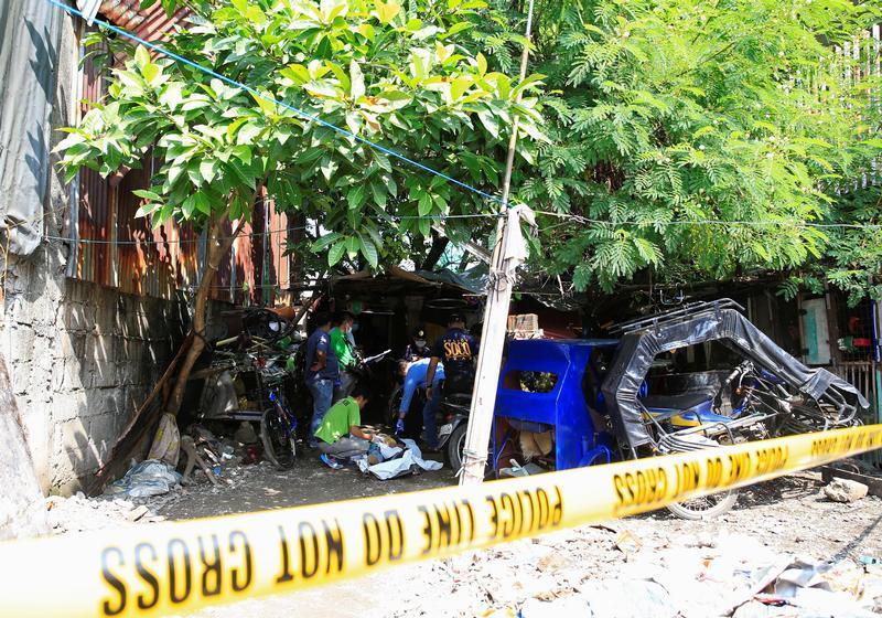 Members of the Philippine National Police (PNP) investigation unit check the body of one of the five suspected drug pushers killed in a police operation in Quiapo city, metro Manila, Philippines July 3, 2016. 