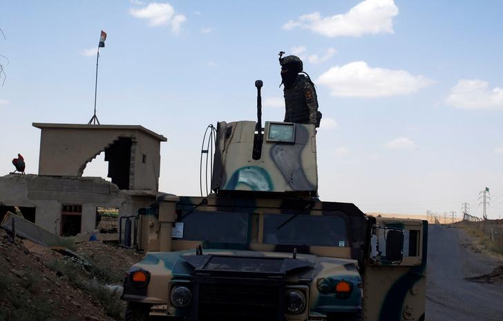 A member of Iraqi security forces stands on the turret of an armoured vehicle along a highway near west of Mosul, Iraq, June 22, 2017. 