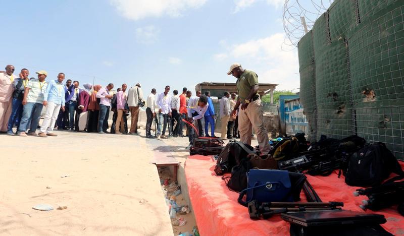Journalists queue for a security sweep outside the venue of the presidential vote at the airport in Somalia's capital Mogadishu