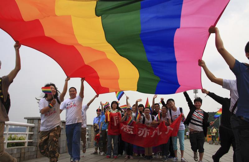 Activists raise a rainbow flag as they march during a demonstration to mark the International Day Against Homophobia and Transphobia in Changsha, Hunan province May 17, 2013.