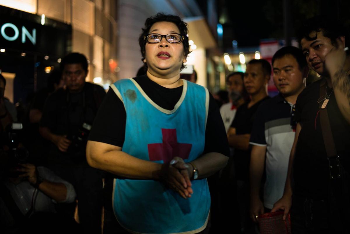 On August 30, 2017, Phayao Akhard wears the bloody nurses gown worn by her daughter, nurse Kamolkate “Kate” Akhard, when she was killed by Thai Special Forces soldiers while tending wounded persons at the front of Wat Pathum temple on May 19, 2010.