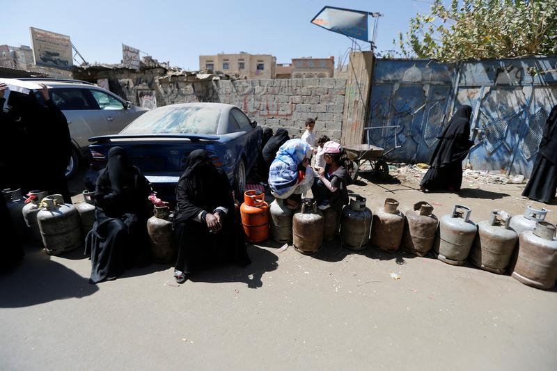 Women sit on cooking gas cylinders lined up outside a gas station amid supply shortage in Sanaa, Yemen November 7, 2017. 